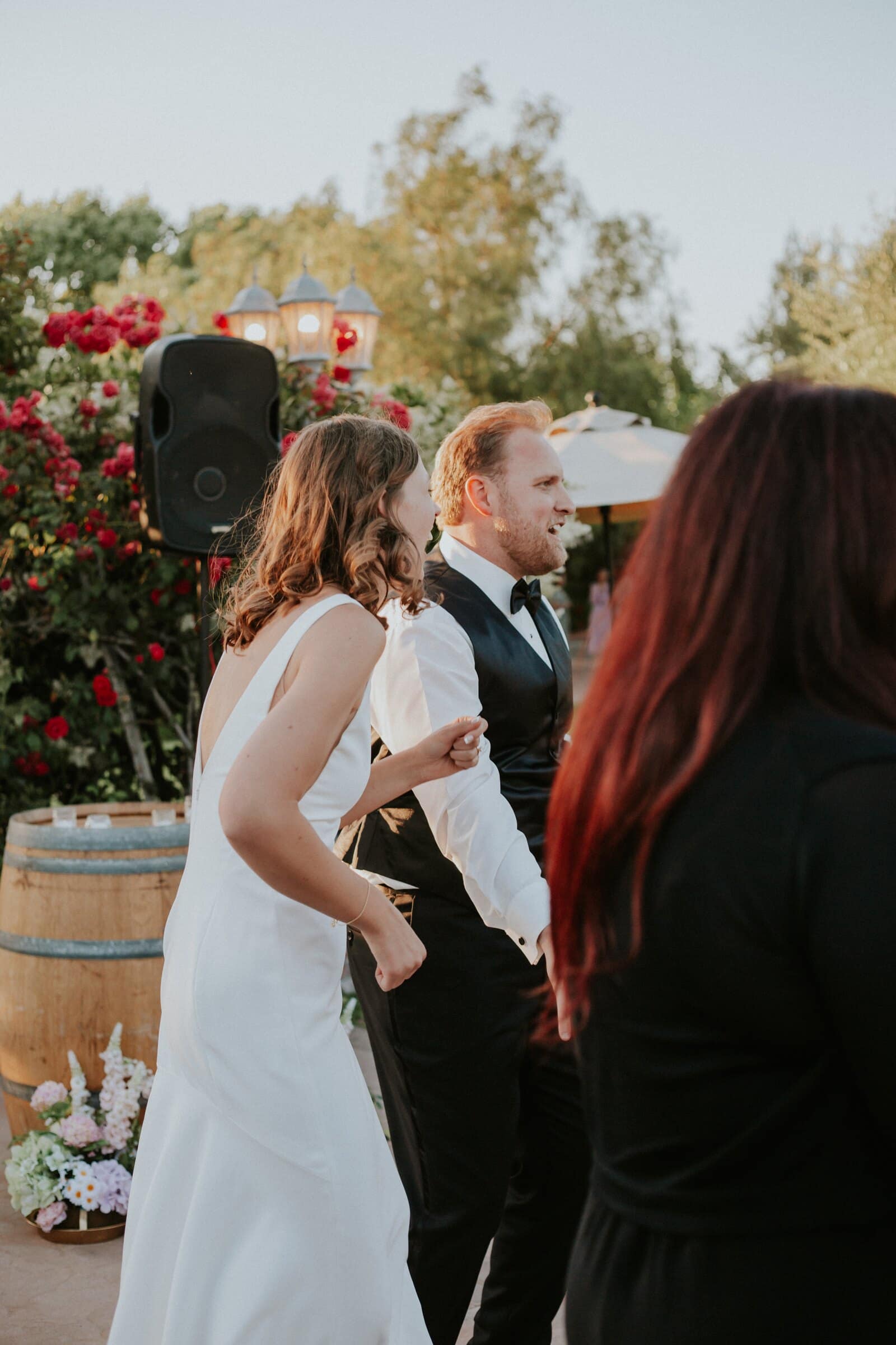Blake and Ava dancing with their guests by the rose bushes