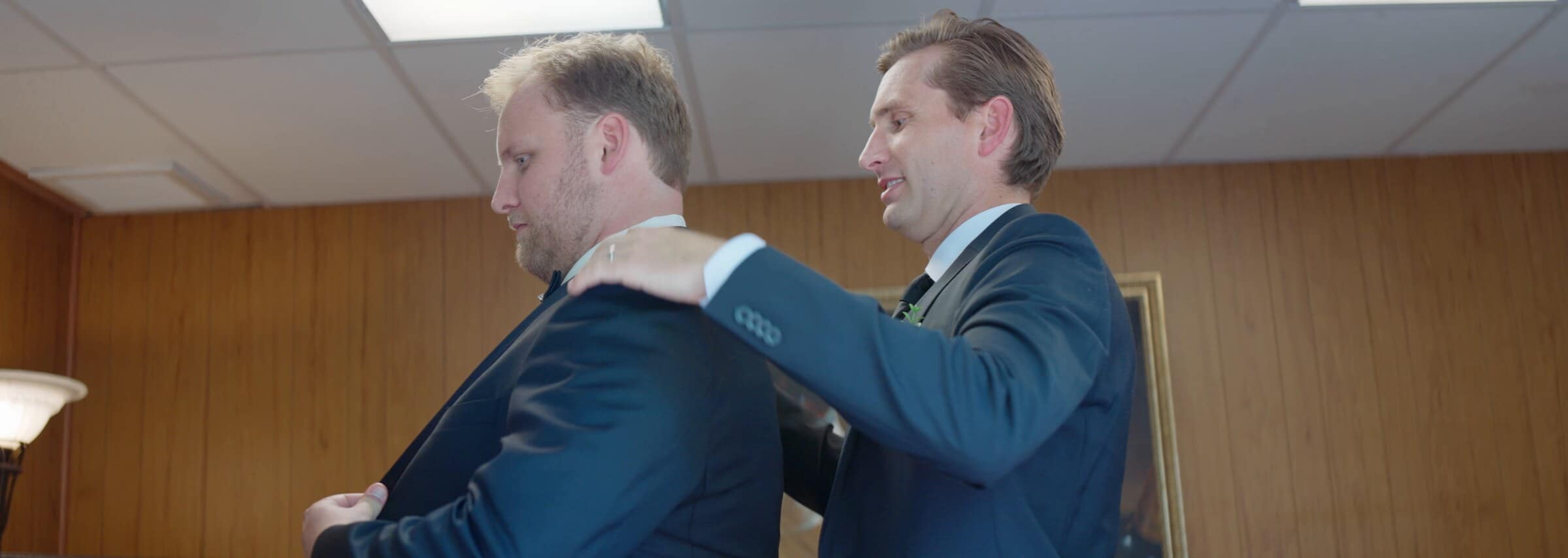 The groom getting help with his jacket before the ceremony