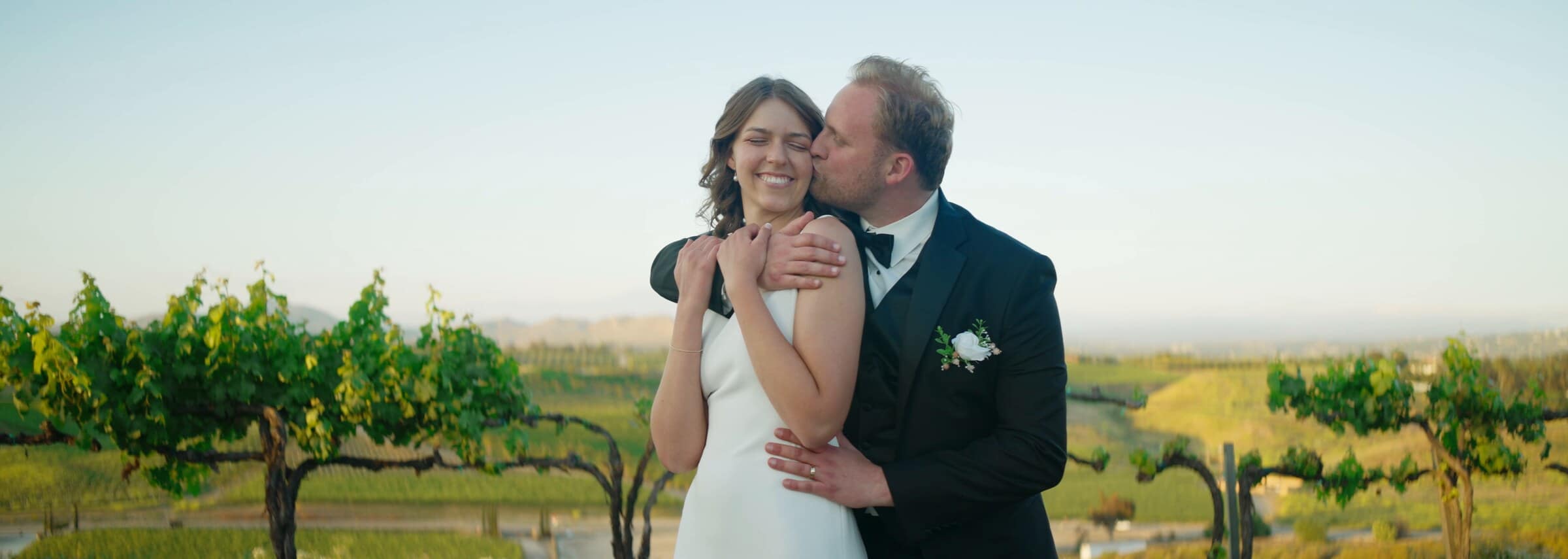 A kiss on the cheek among the vineyard rows