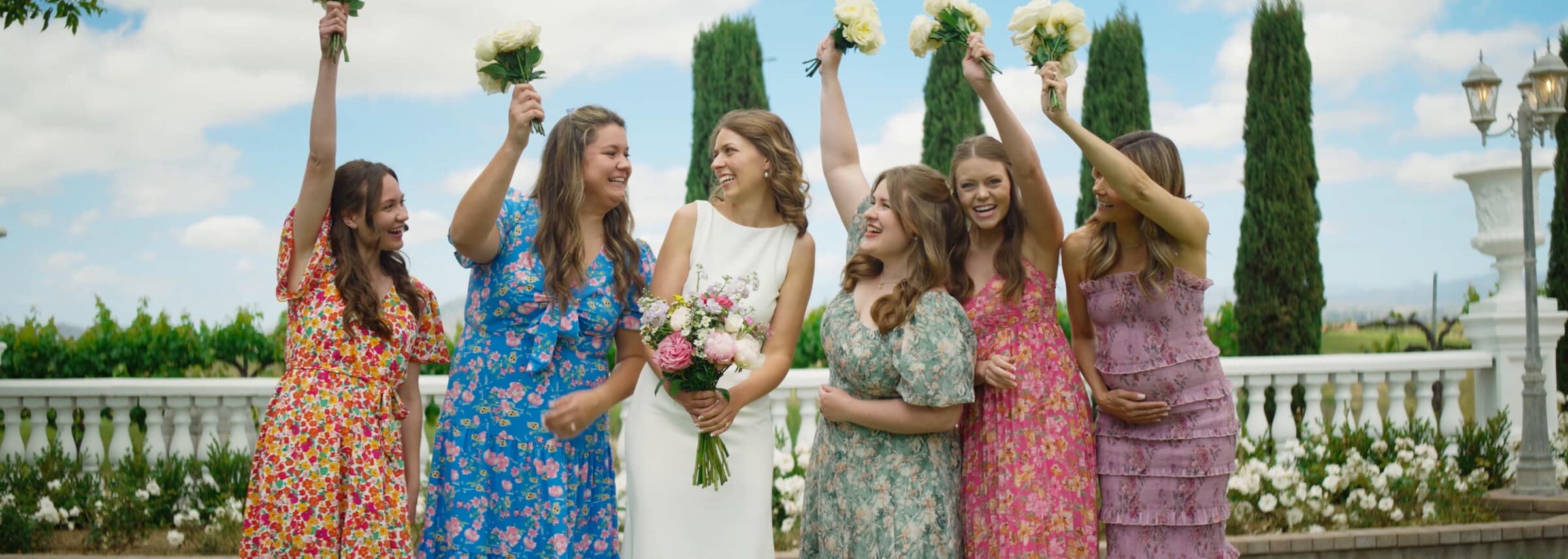 The bride and her bridesmaids raising their bouquets