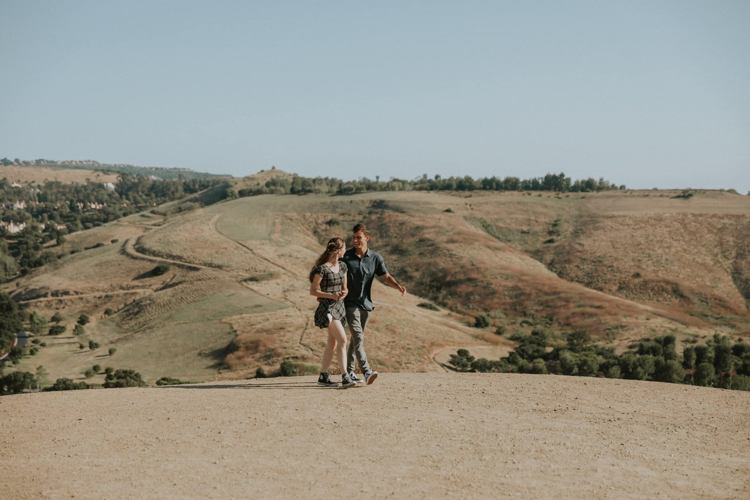 Bryce and Claire on a dirt trail across golden hills