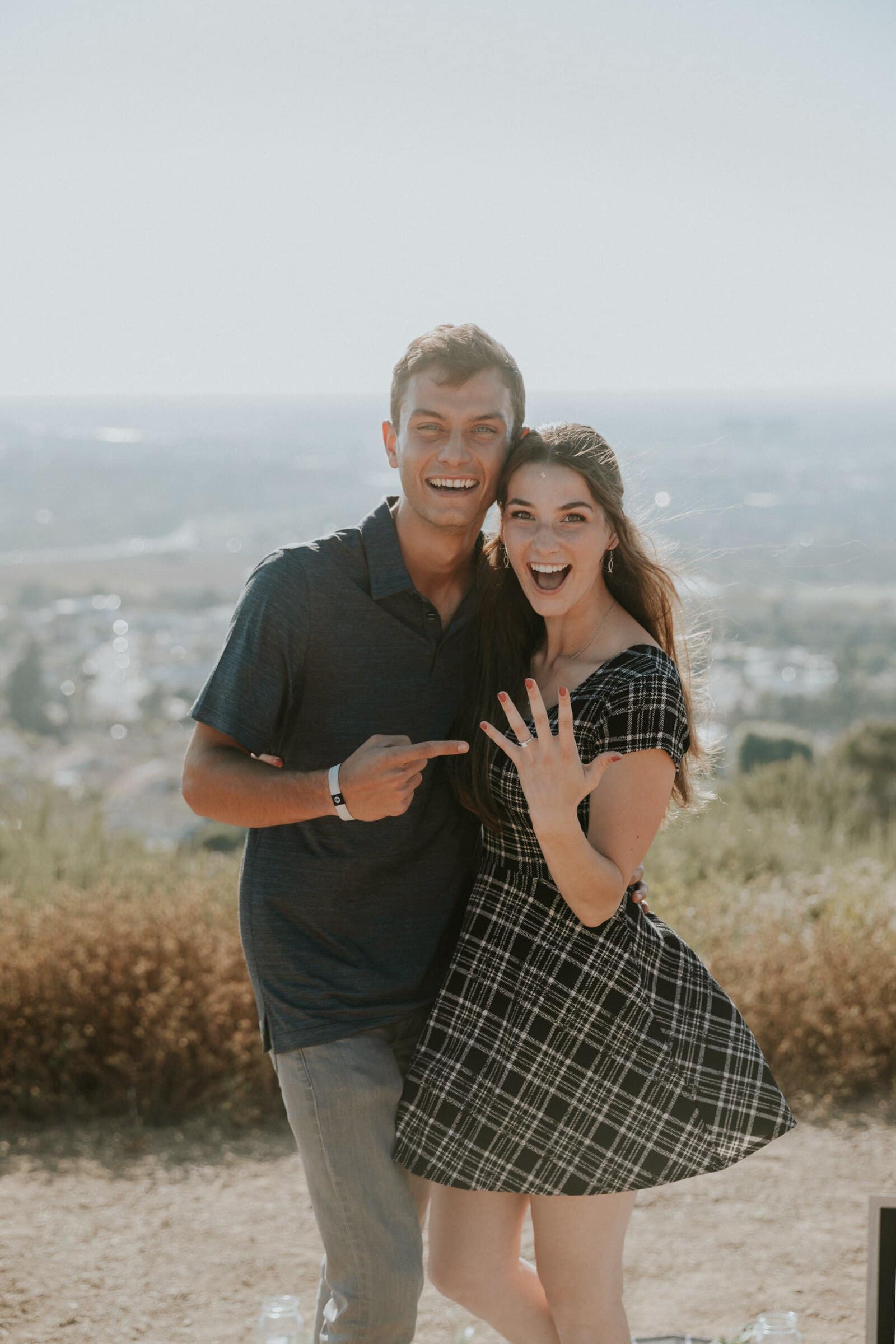 Bryce and Claire laughing, her ring hand on his chest