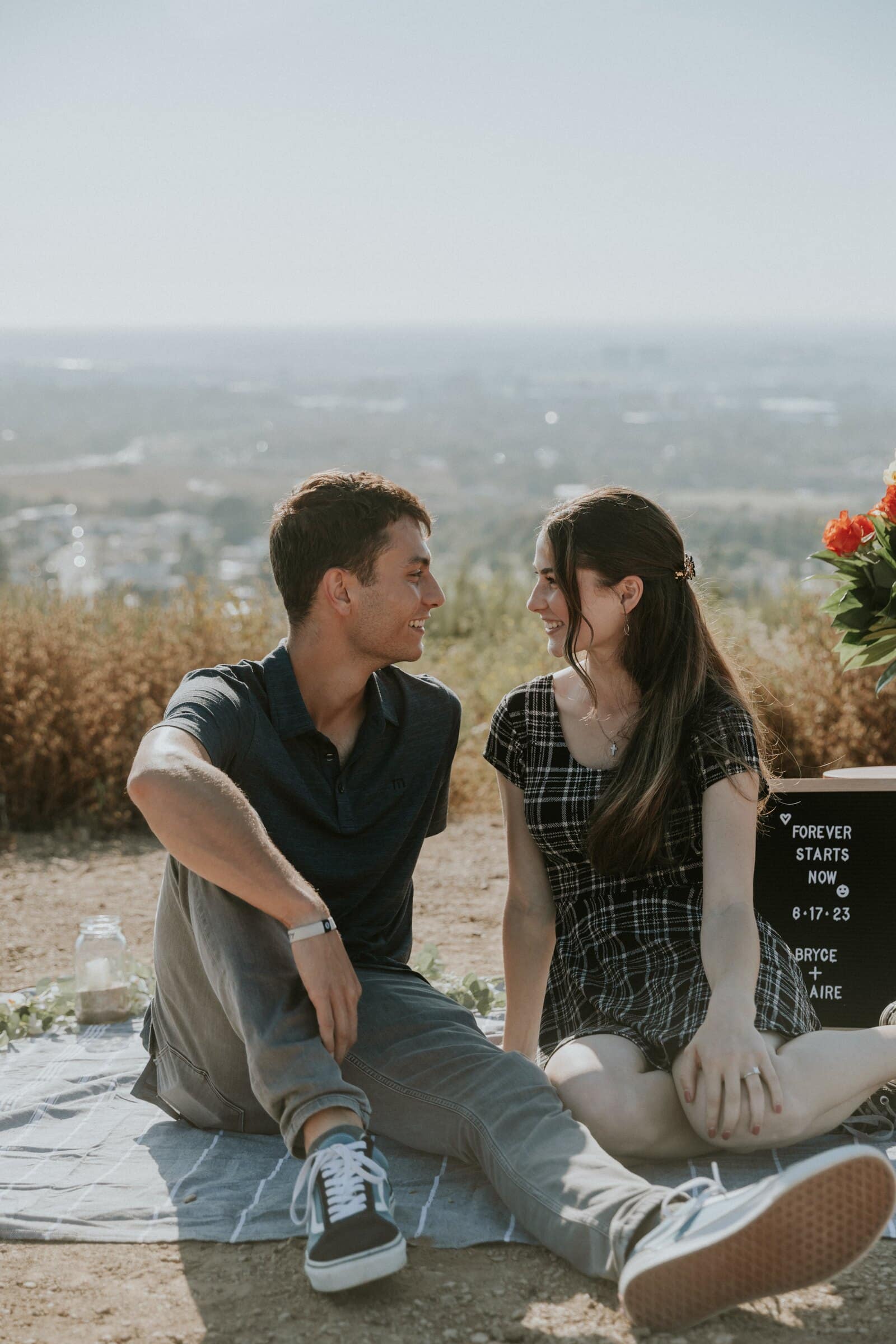 Bryce and Claire sitting on a blanket beside the flowers