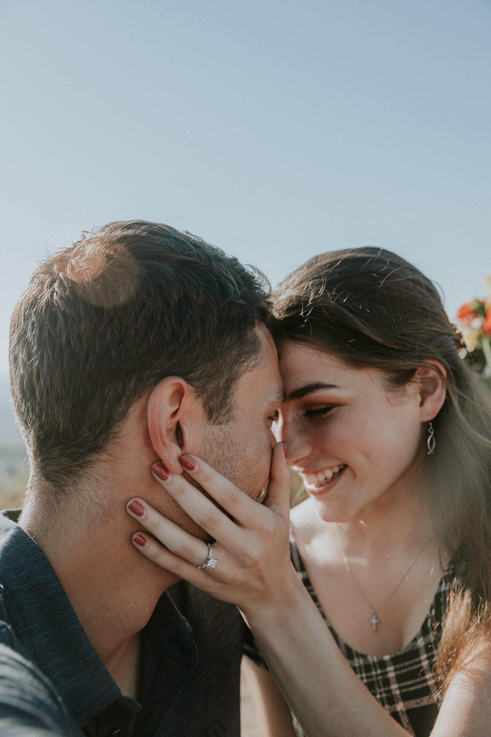 Claire's ring hand on Bryce's cheek, foreheads touching