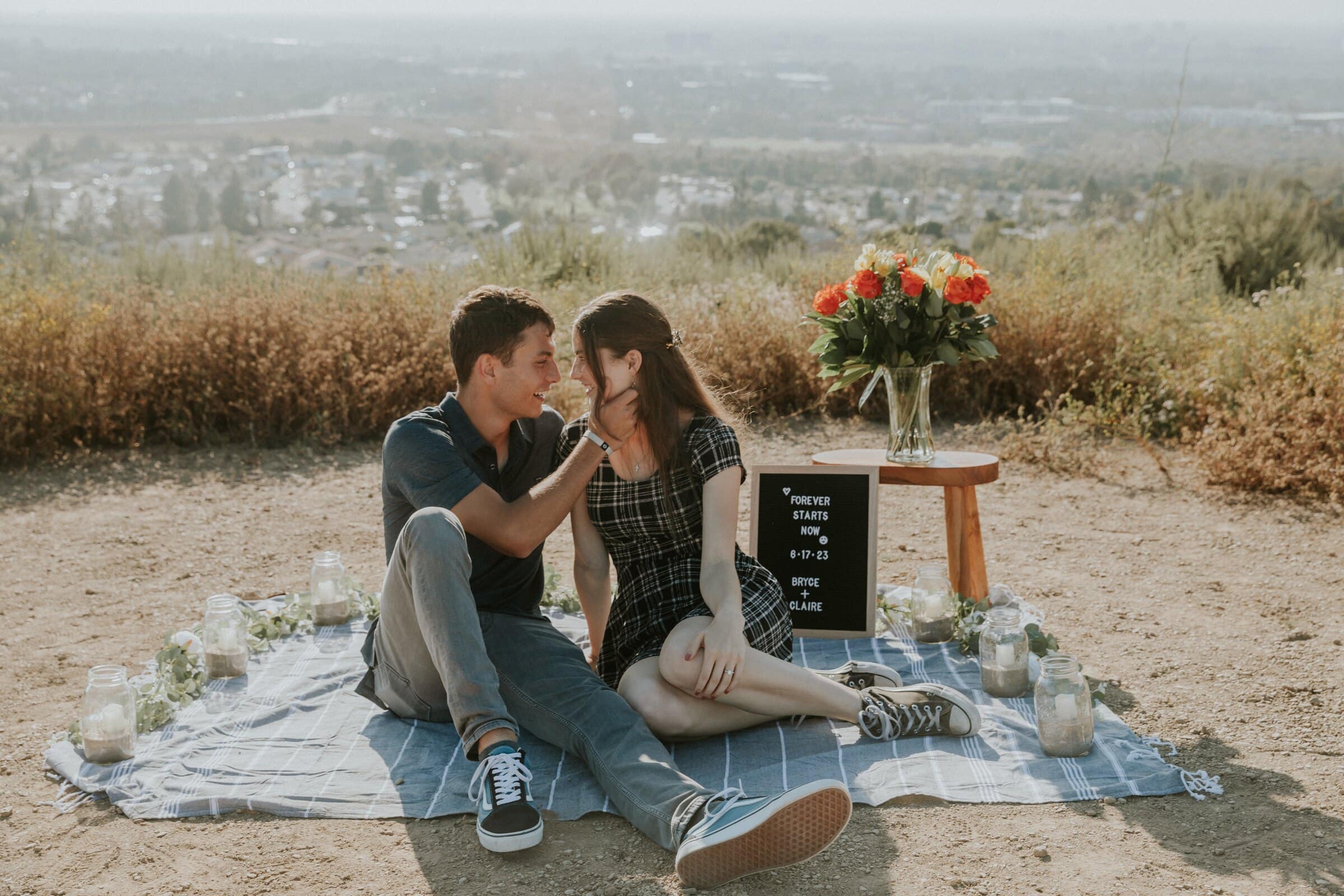 Bryce and Claire on the picnic blanket, the valley behind them