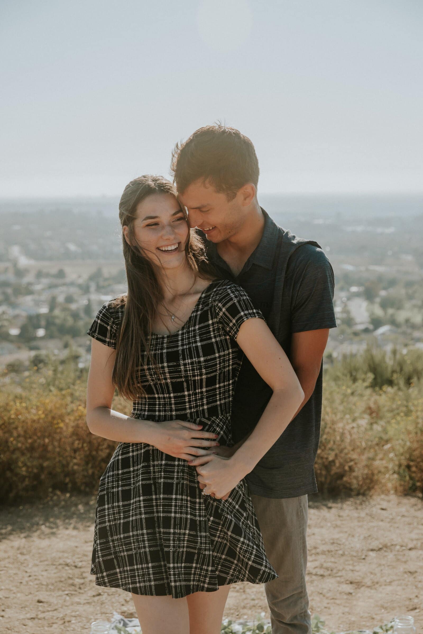 Bryce and Claire smiling, his arms around her waist