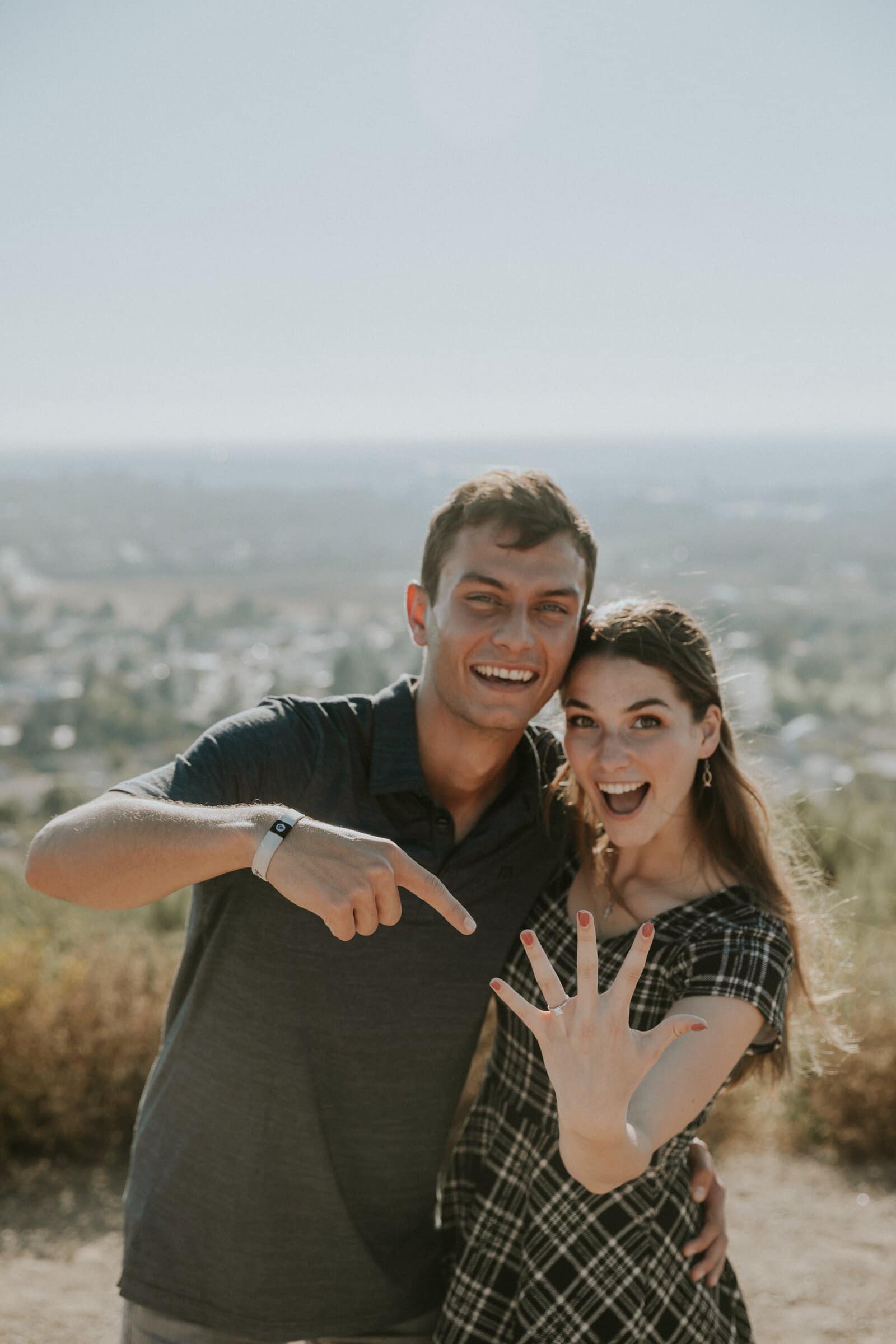 Bryce pointing at Claire's ring as they laugh