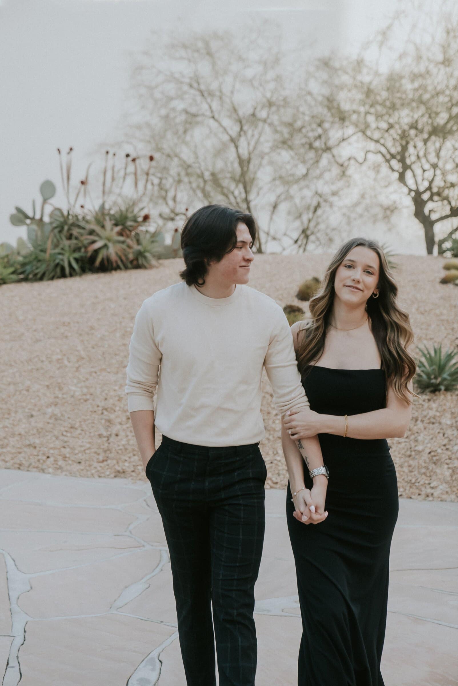 Cameron and Amanda walking side by side through a desert garden