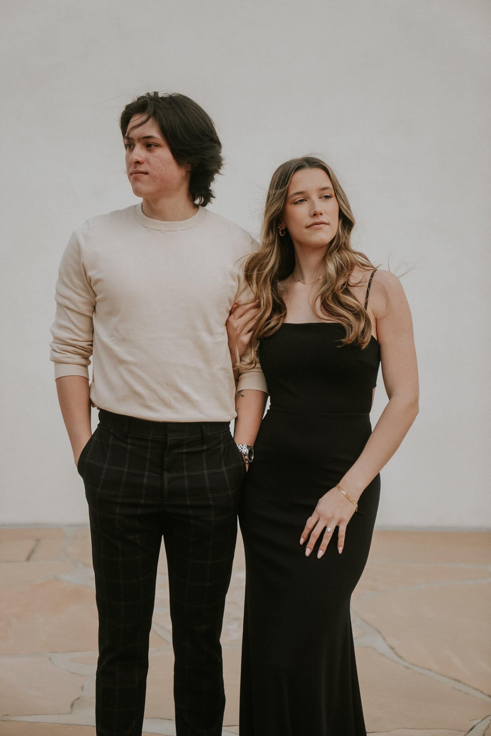 Cameron and Amanda standing together in front of a white wall