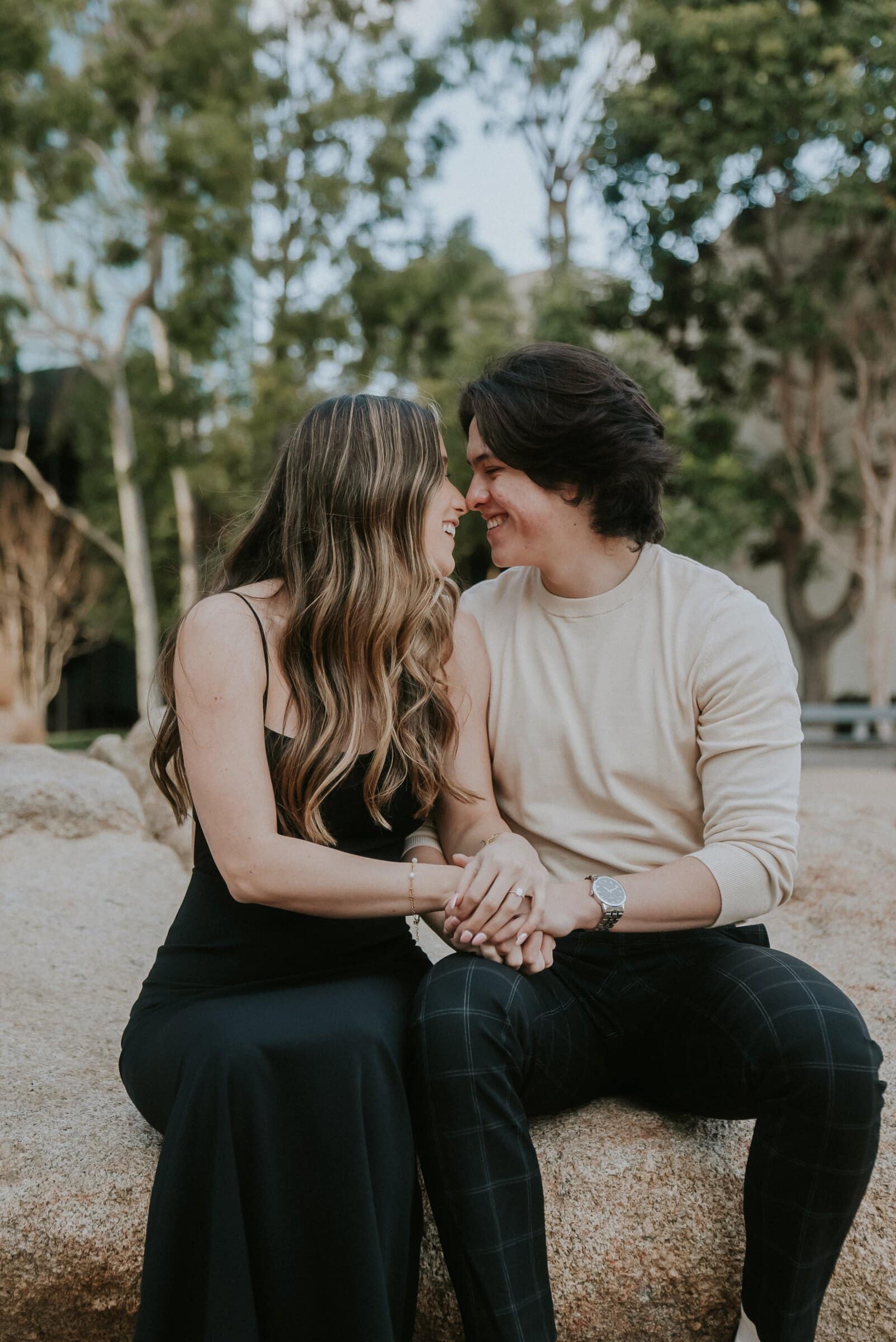 Cameron and Amanda sitting on a rock, foreheads close