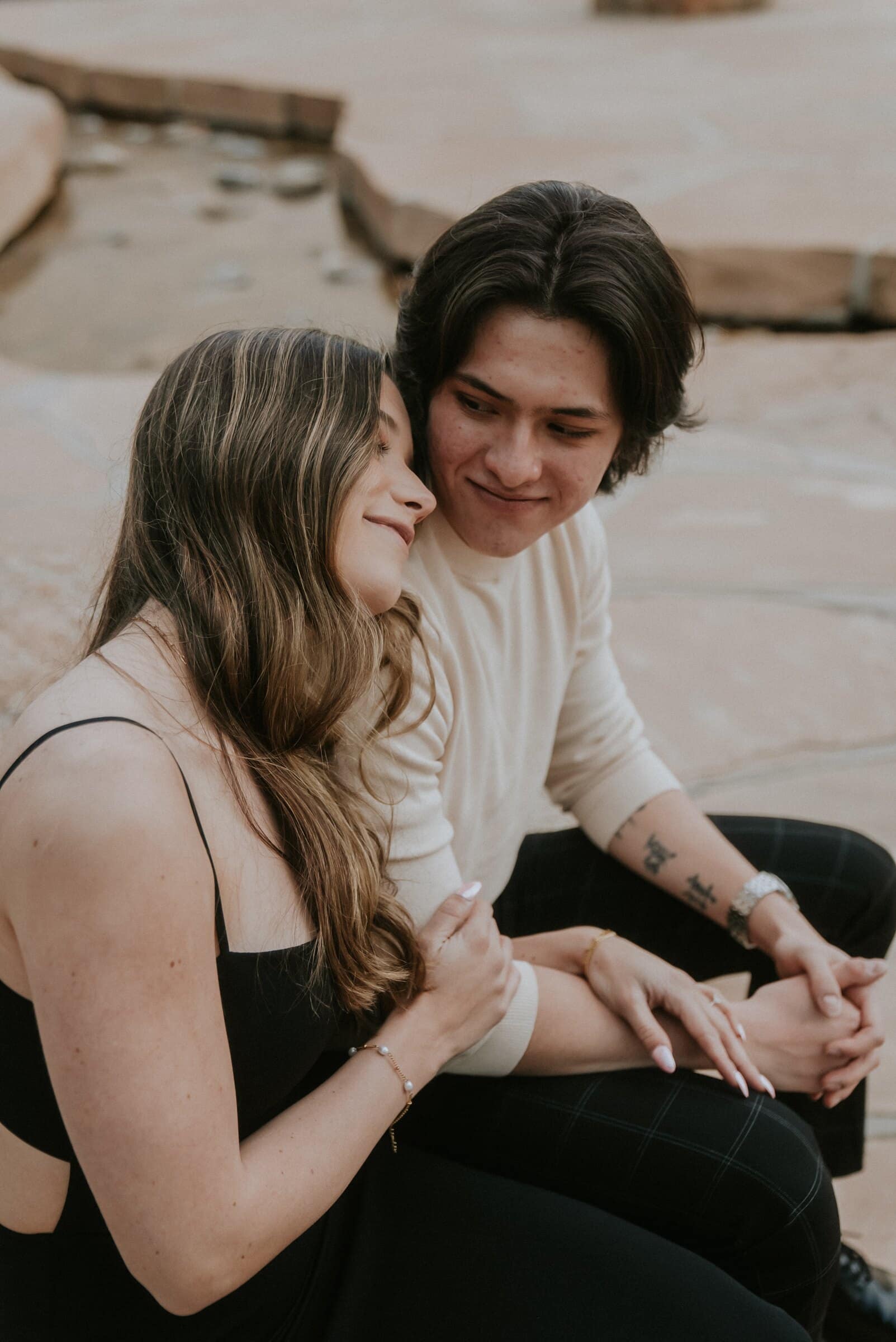Cameron and Amanda sitting close by a stream, smiling