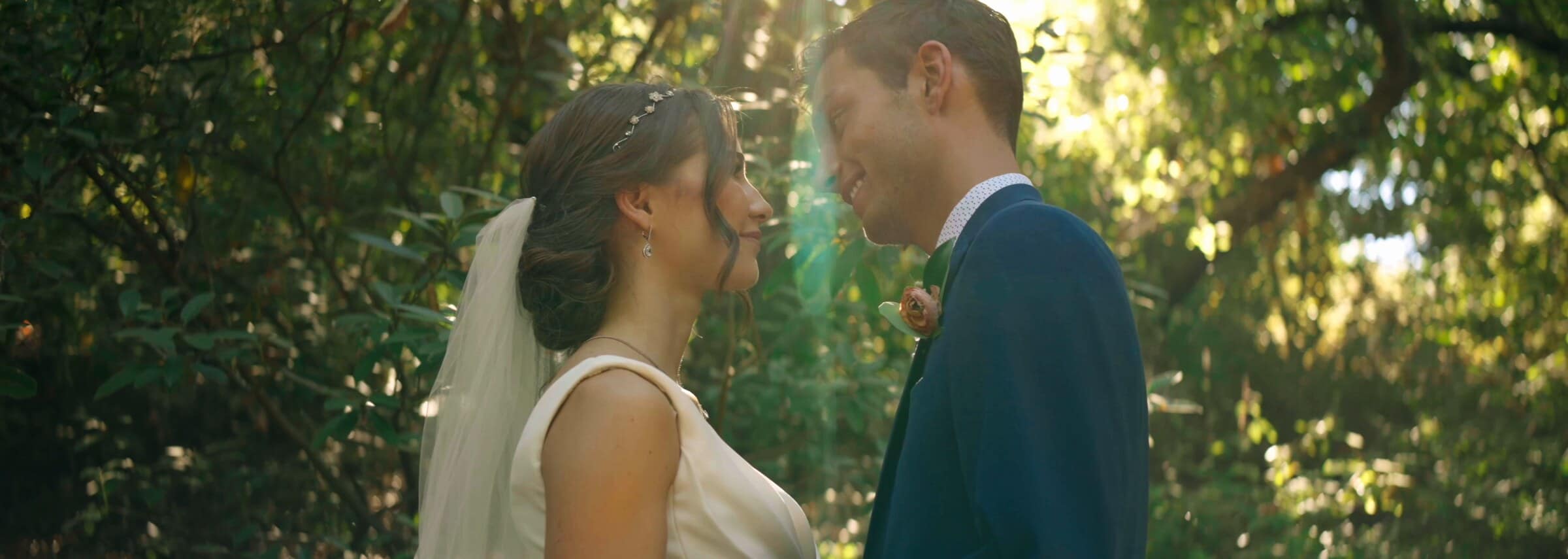 Claire and Bryce close together under the trees