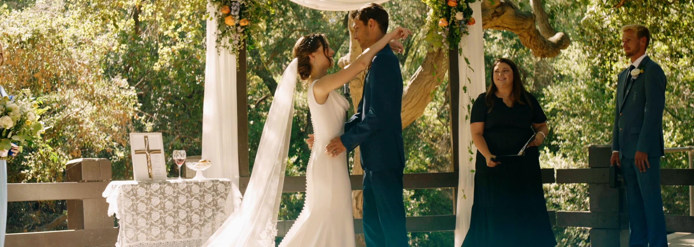 Claire and Bryce's first kiss at the altar under a white drape