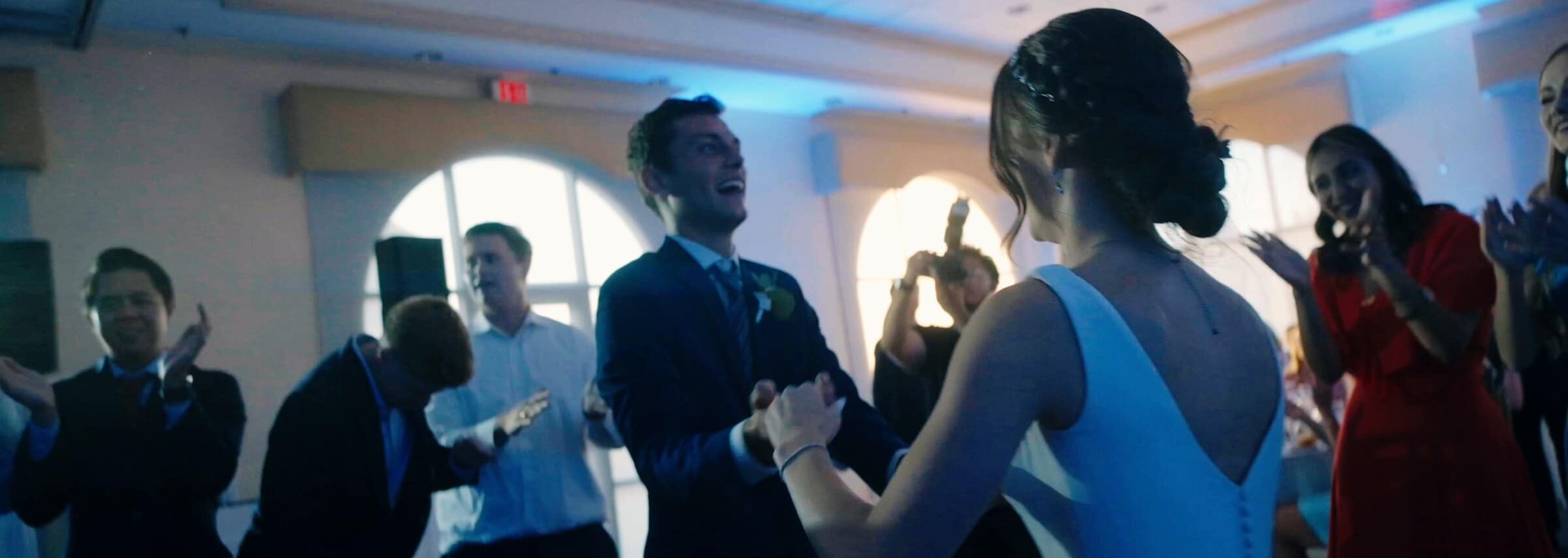 The bride and groom dancing in a crowd of cheering guests