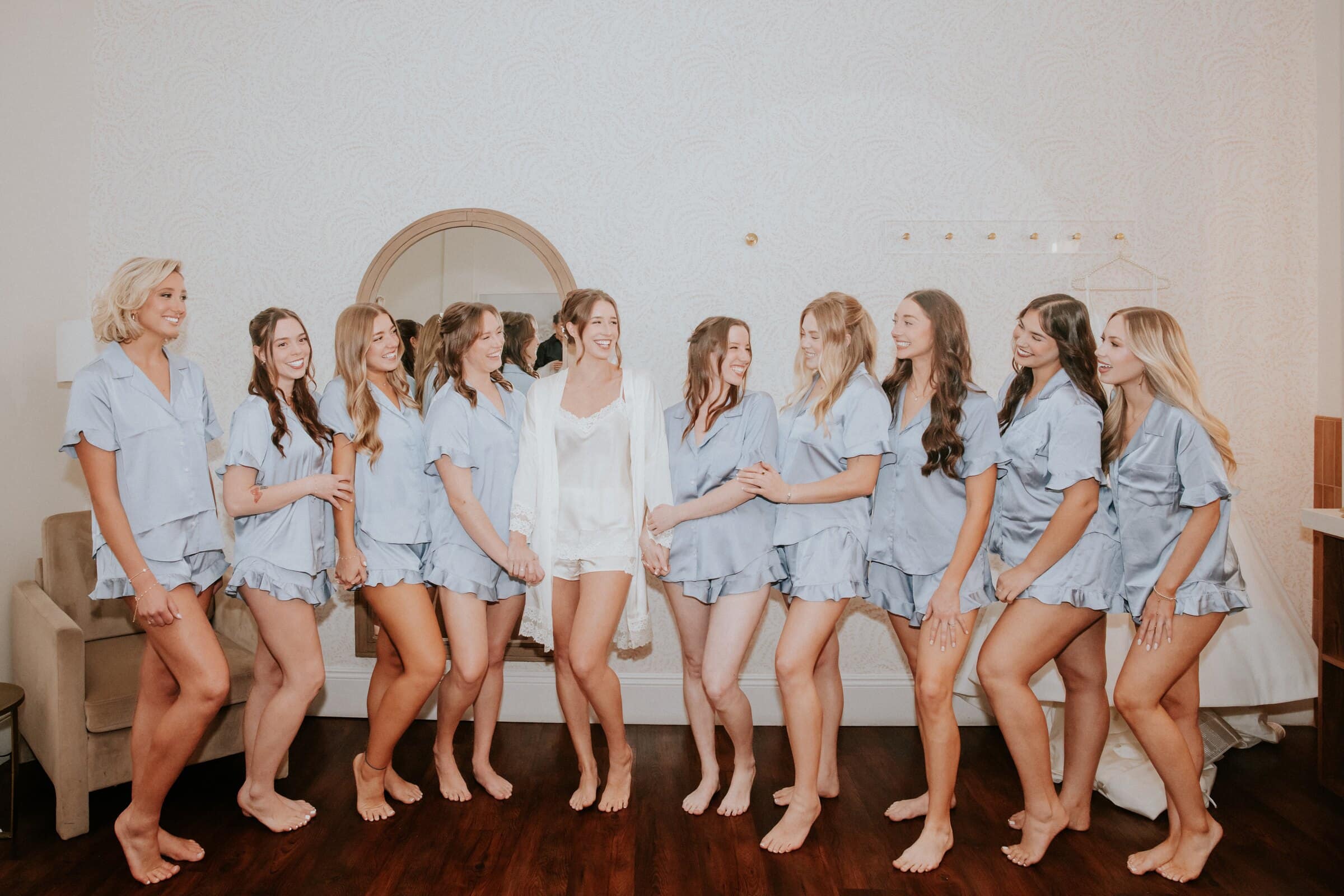 Clara and her bridesmaids in matching blue pajamas in a bright room