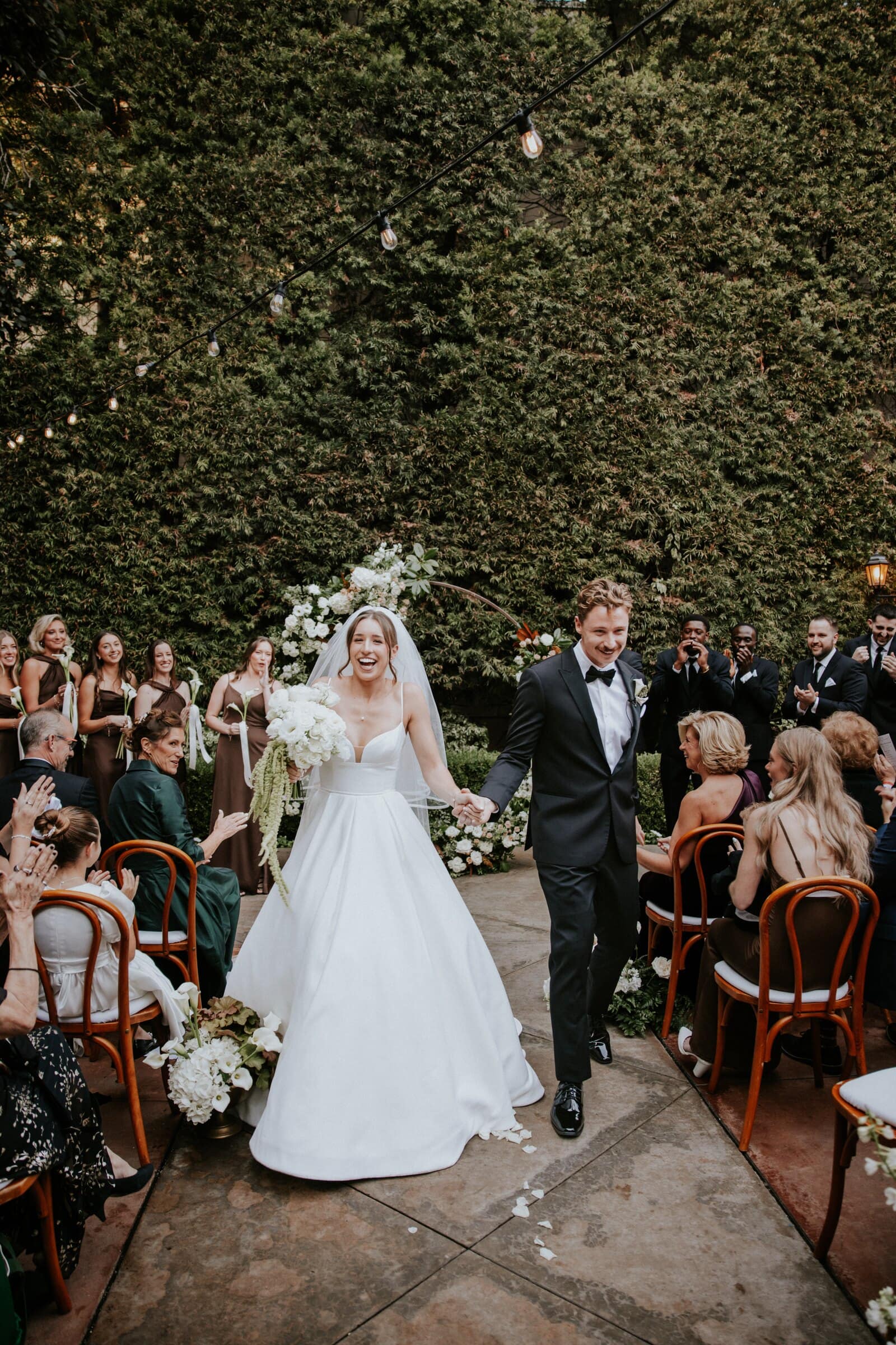 Clara and Grant walking back up the aisle as guests cheer