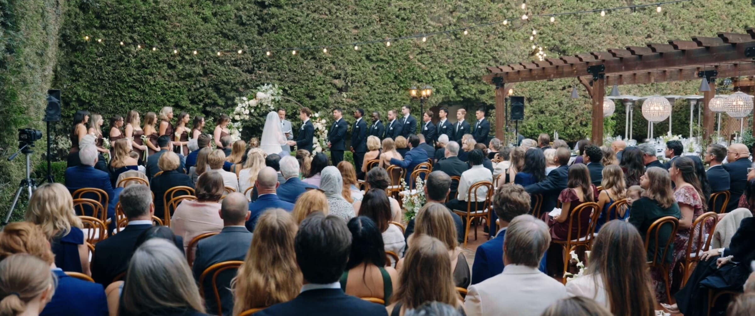 Guests seated in the ivy-walled courtyard during the ceremony