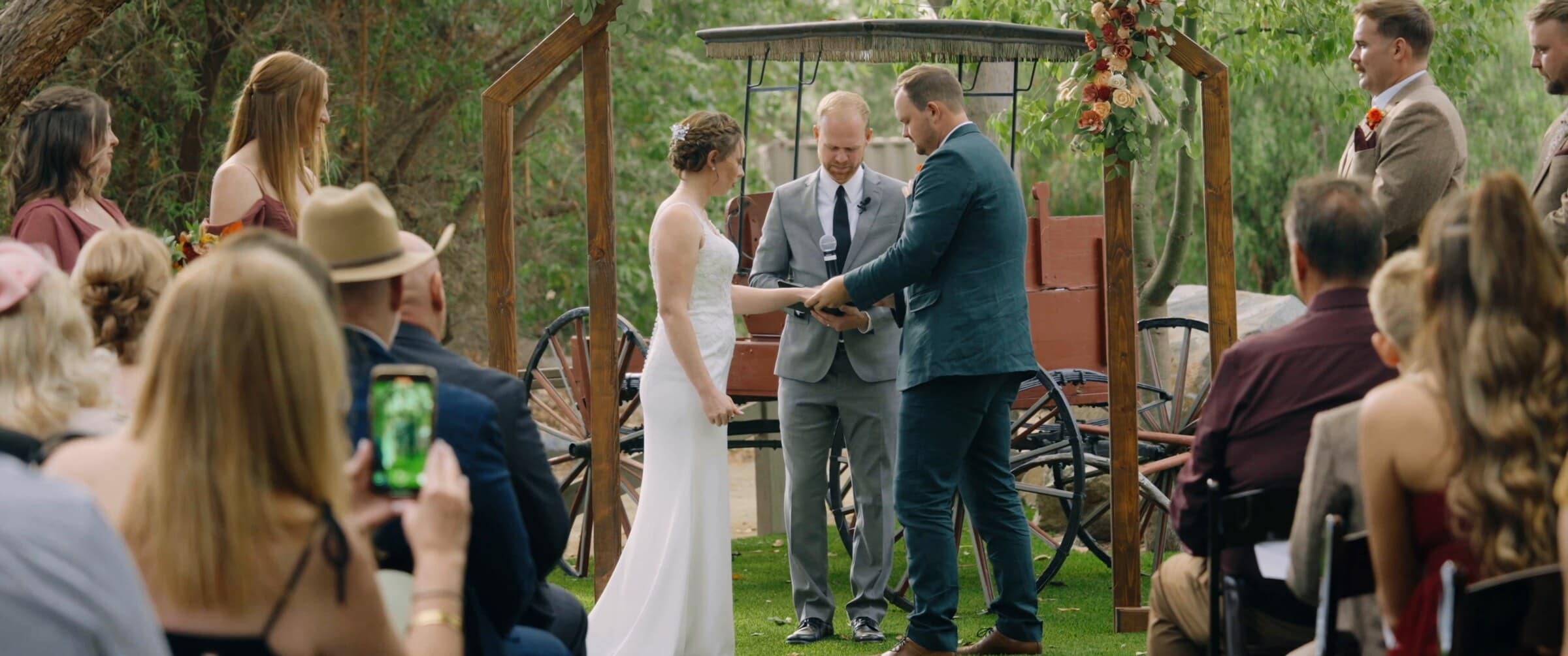The ceremony beside an old red wagon, guests watching from their seats