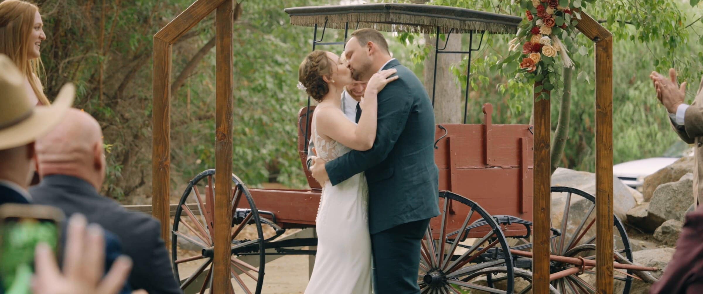 Danika and Paxton's first kiss as a married couple beneath the wooden arbor