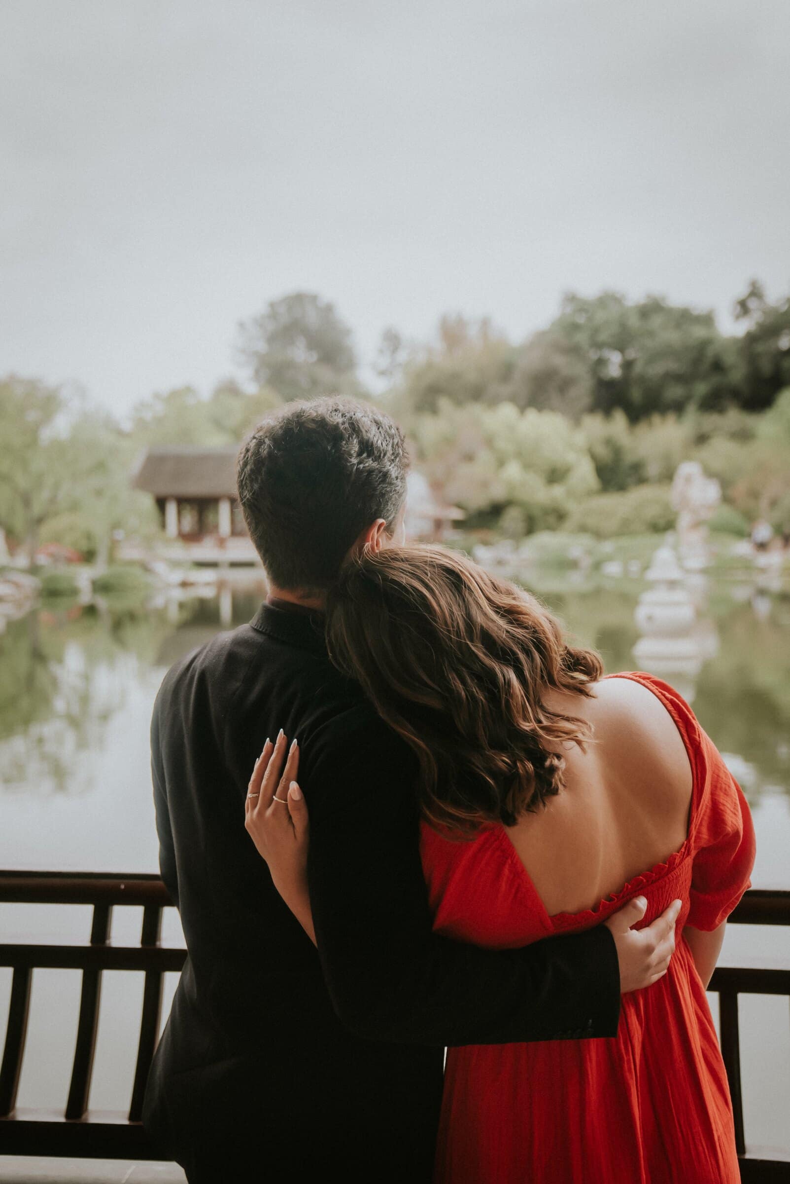 David and Natalie seen from behind, arm in arm by the water