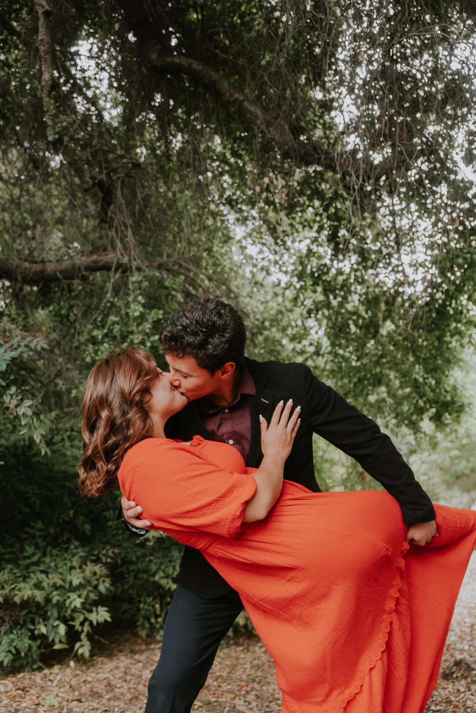 David dipping Natalie for a kiss beneath the trees