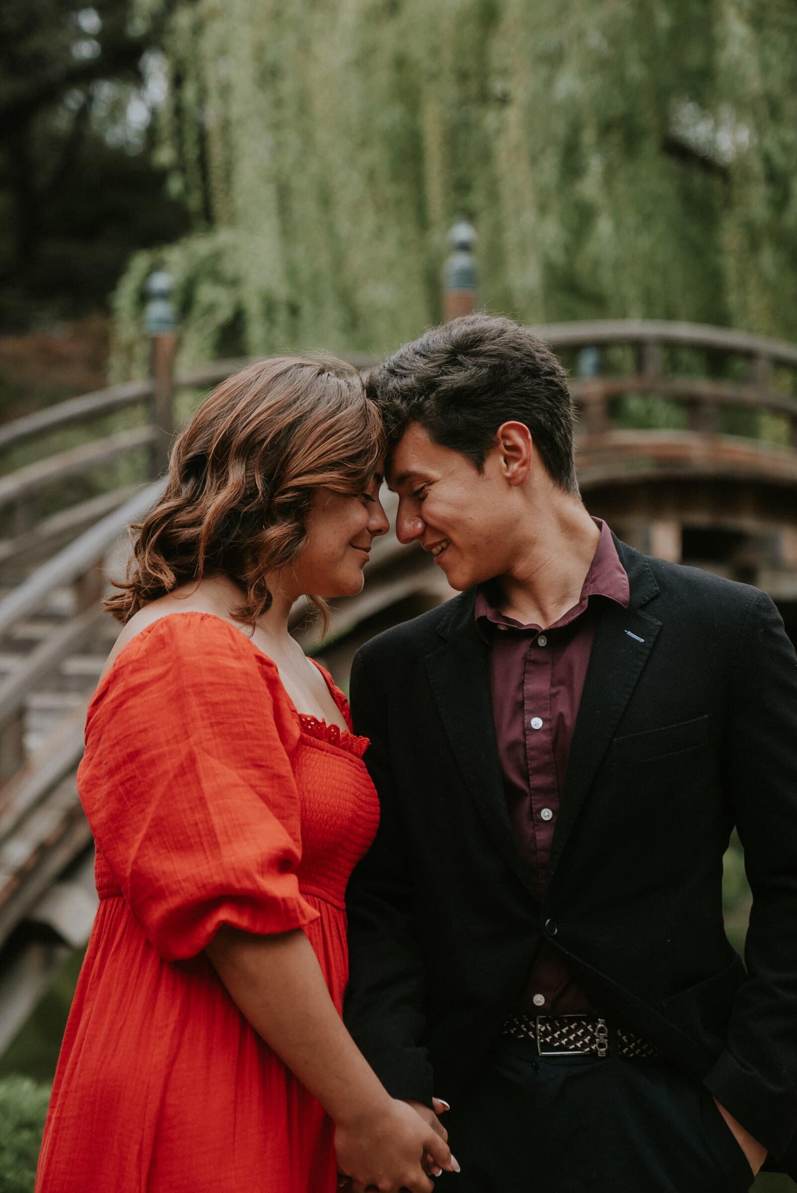 David and Natalie forehead to forehead by a wooden bridge