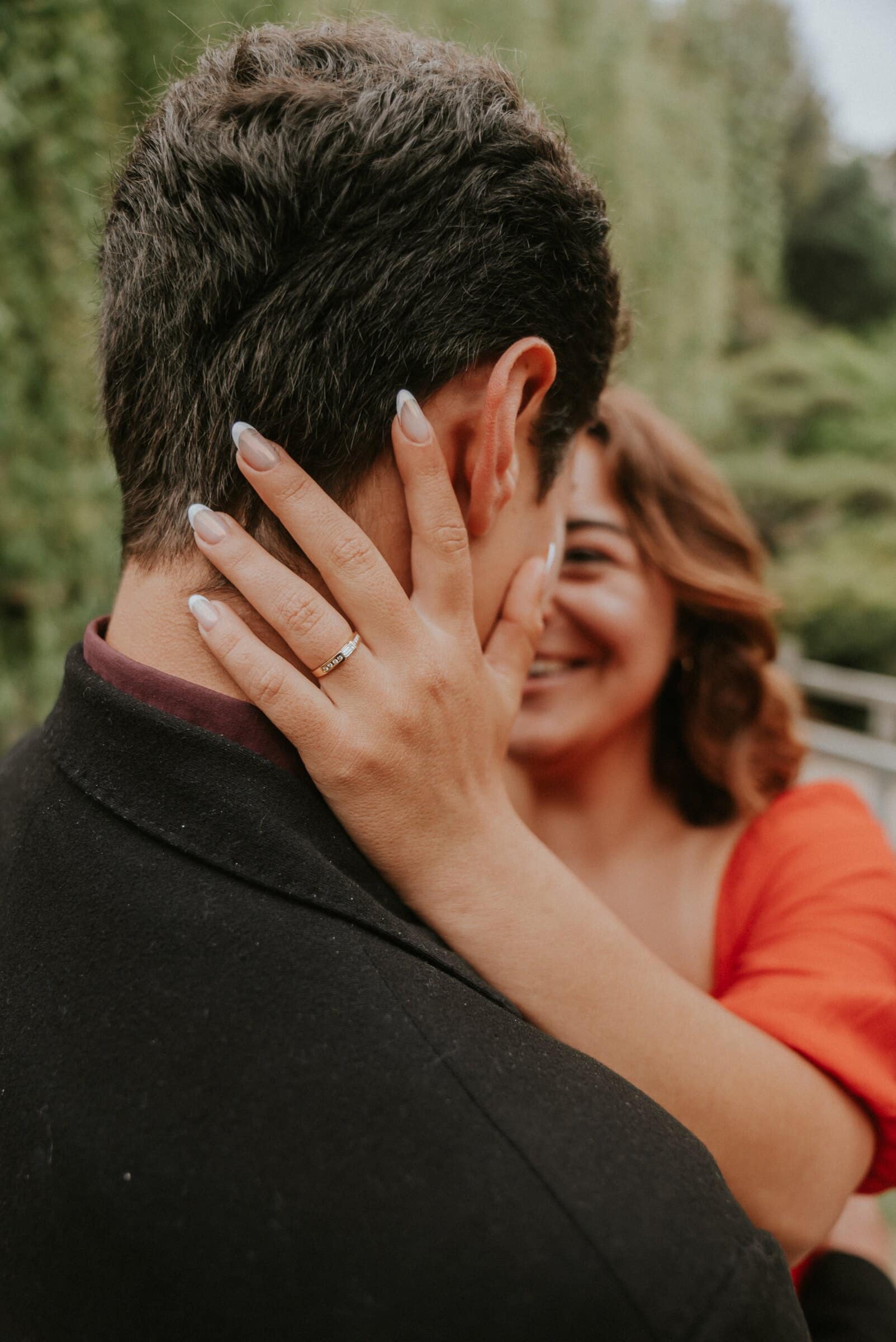 Natalie's ring hand on David's cheek as they kiss