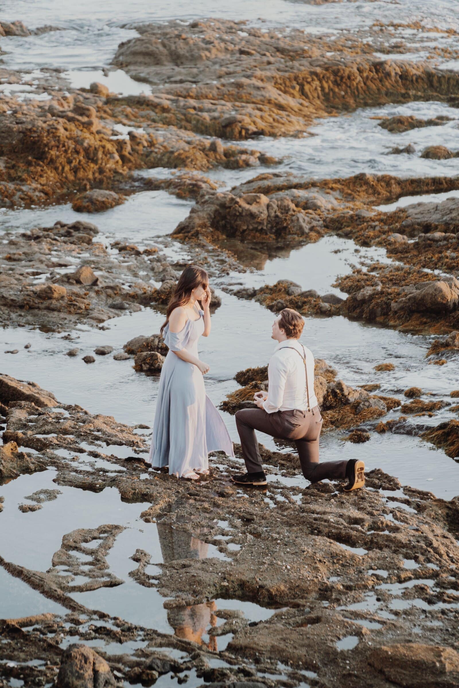 Dylan on one knee on the rocks in front of Jasmine