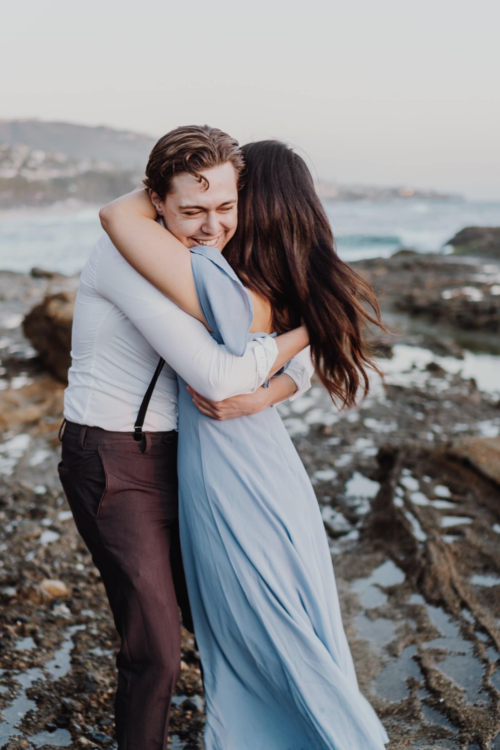 Dylan and Jasmine hugging and laughing on the shore