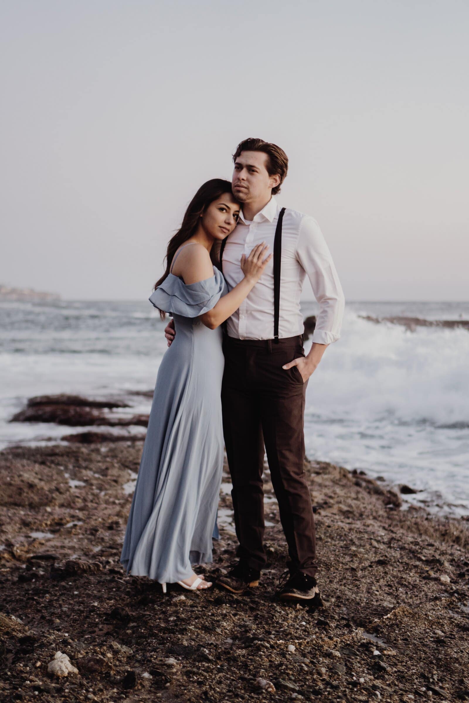 Dylan and Jasmine standing close as the waves come in