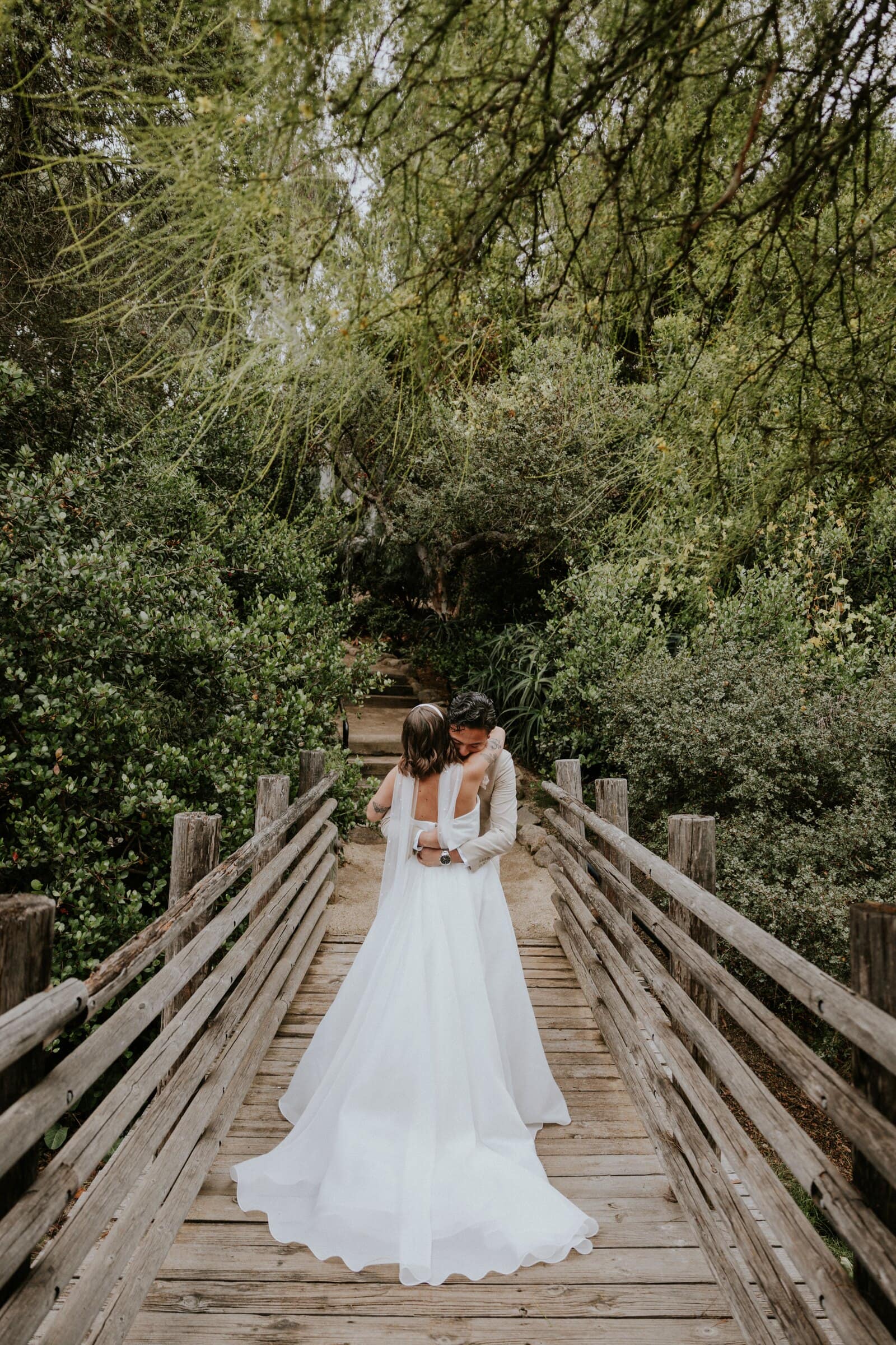 Megan and Caleb's first look on a wooden footbridge