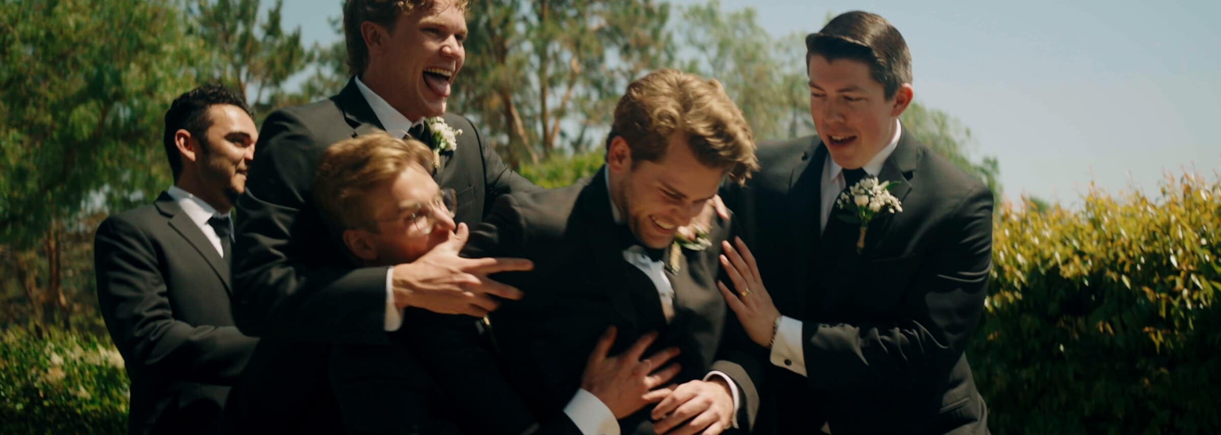 The groomsmen laughing and grabbing each other