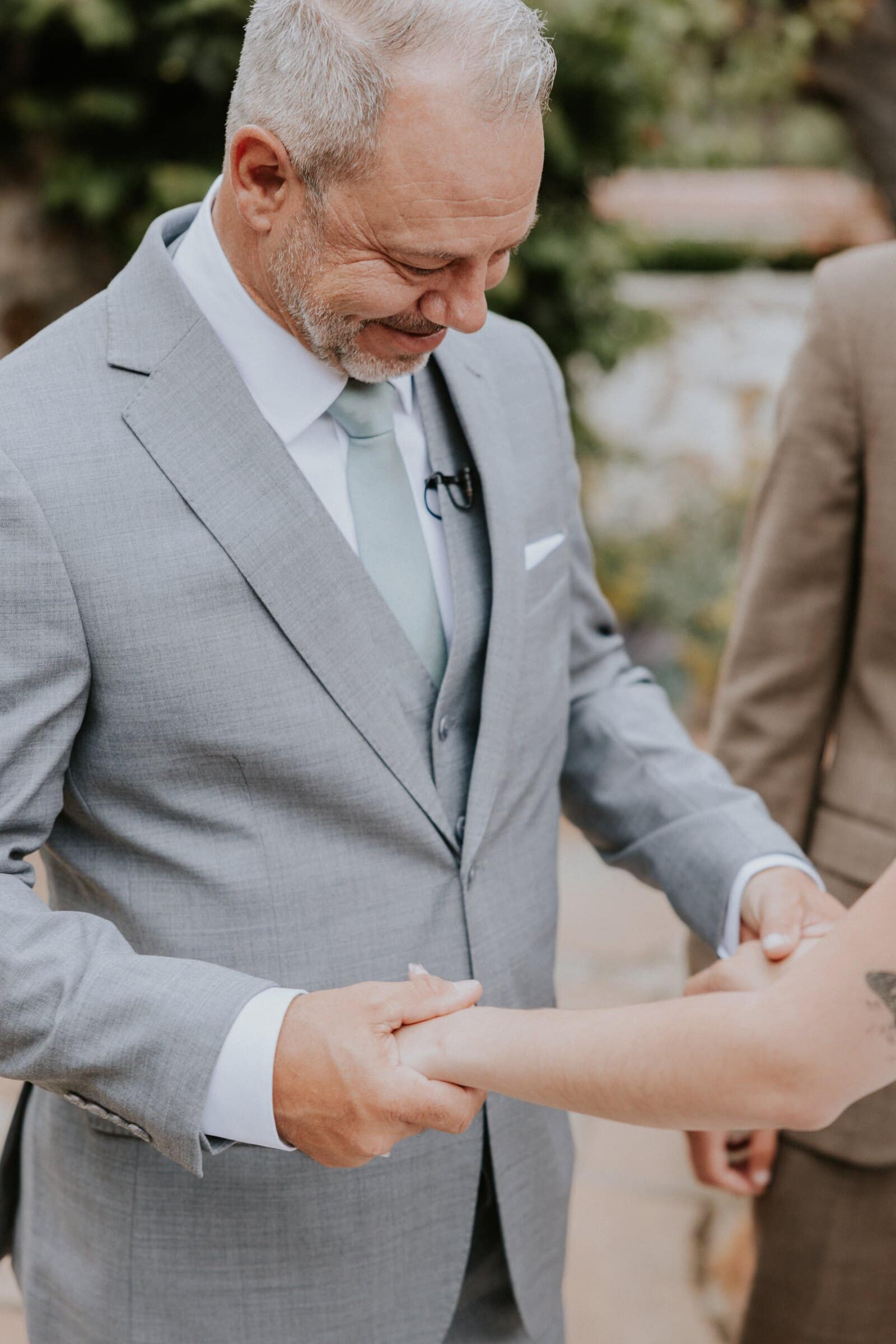 A man in a grey suit laughing as he sees Megan