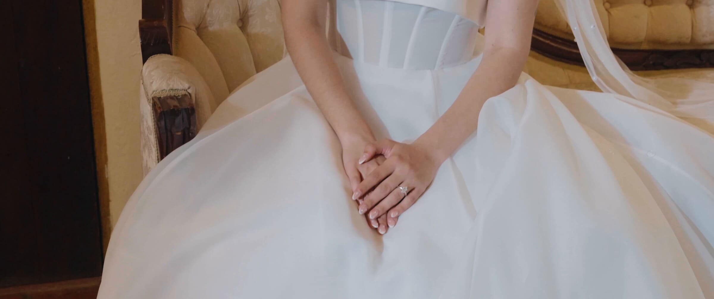 Megan's hands folded over her wedding dress