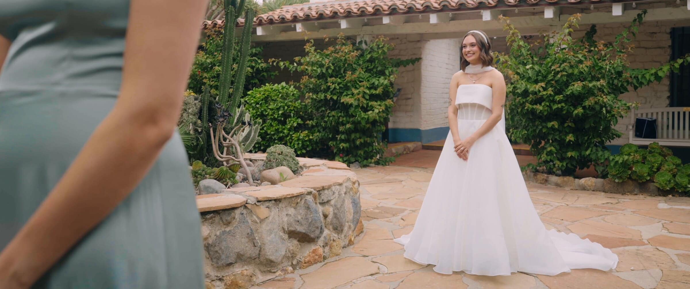 Megan standing in a stone courtyard in front of a whitewashed adobe