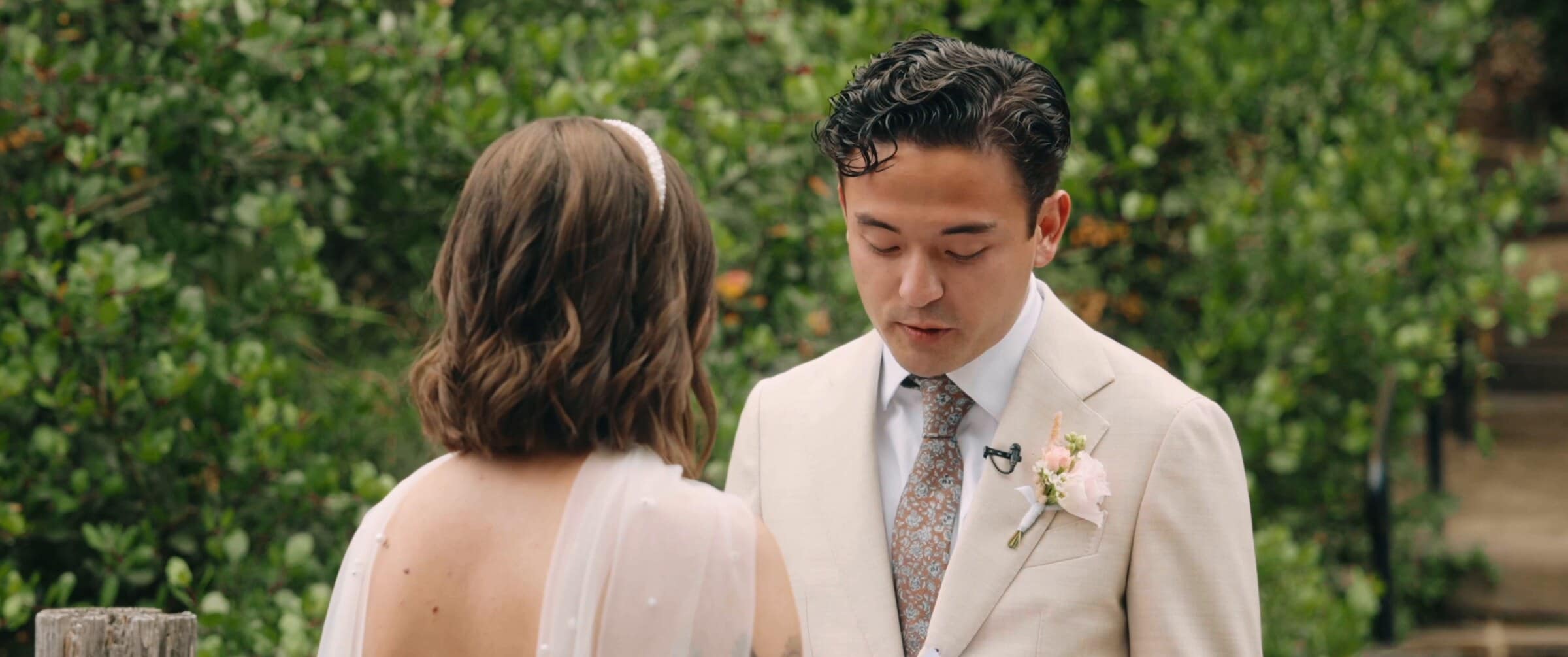 Megan and Caleb facing each other at their first look among the trees