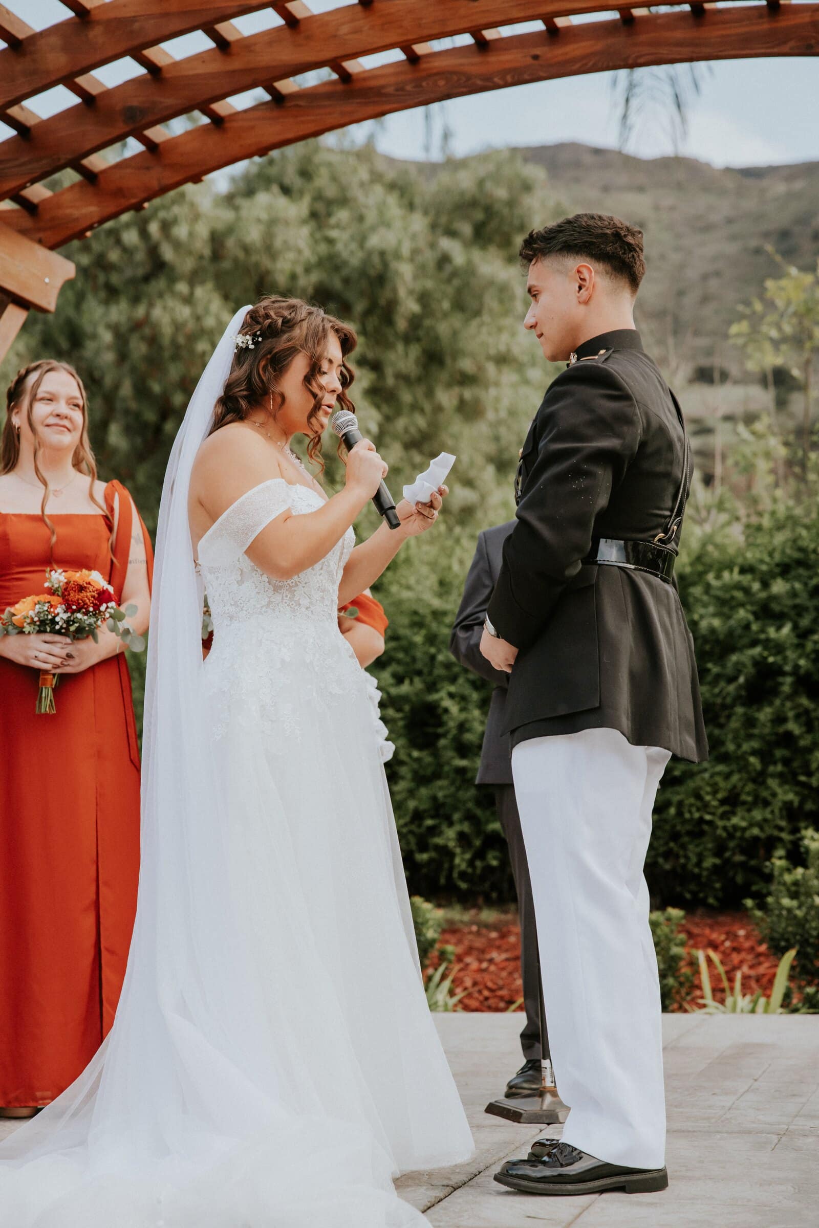 Natalie reading her vows under the wooden pergola