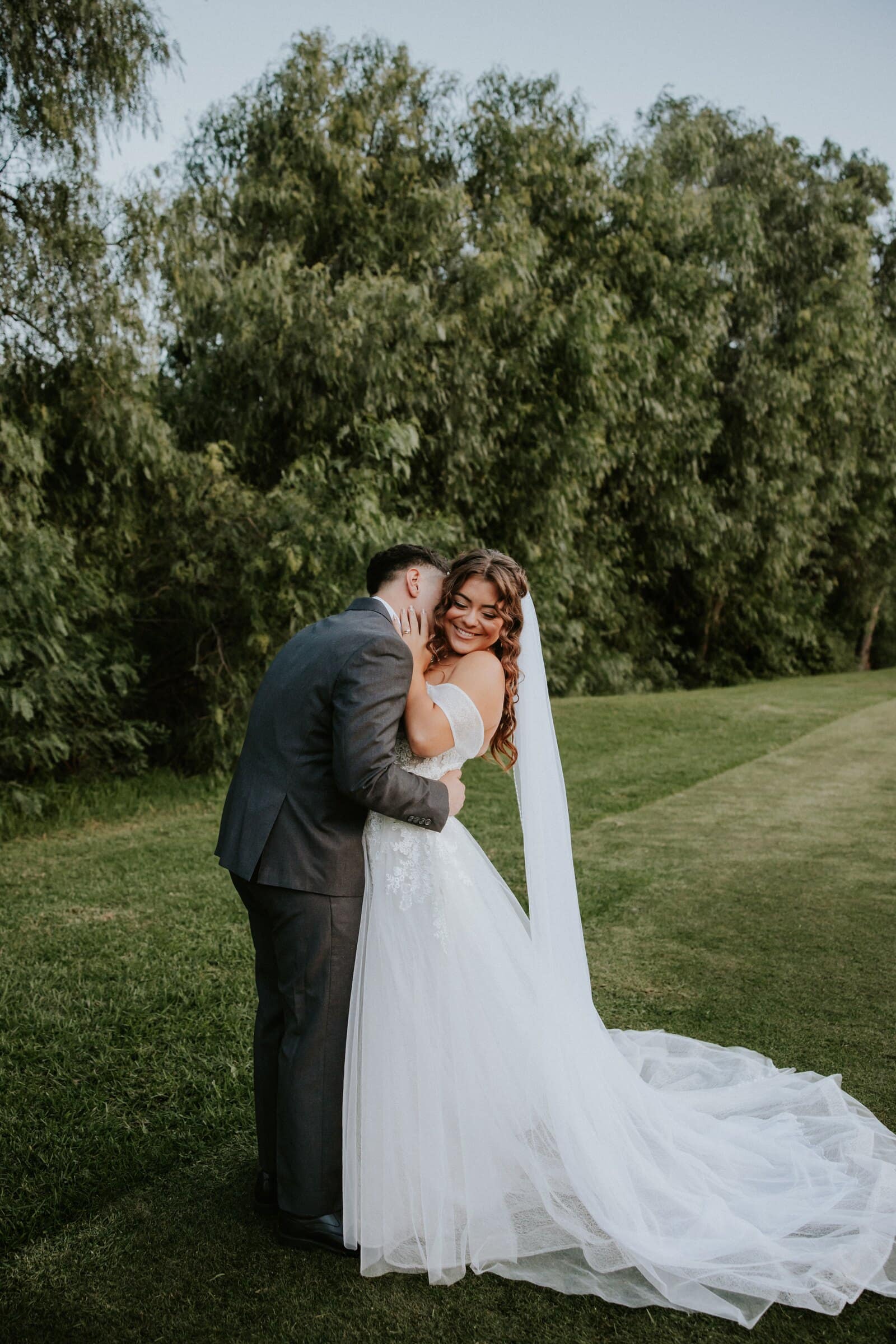 Natalie and David kissing on the lawn