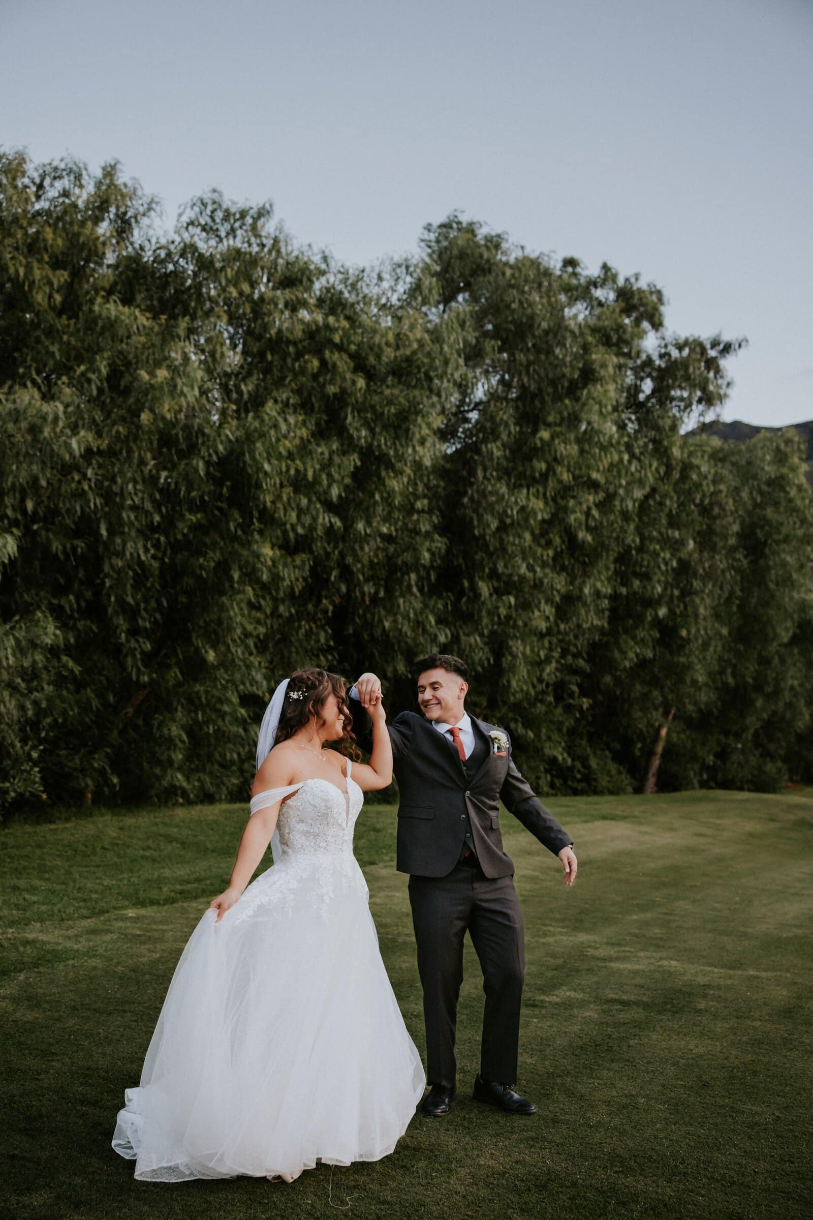 Natalie and David laughing as they walk across the lawn