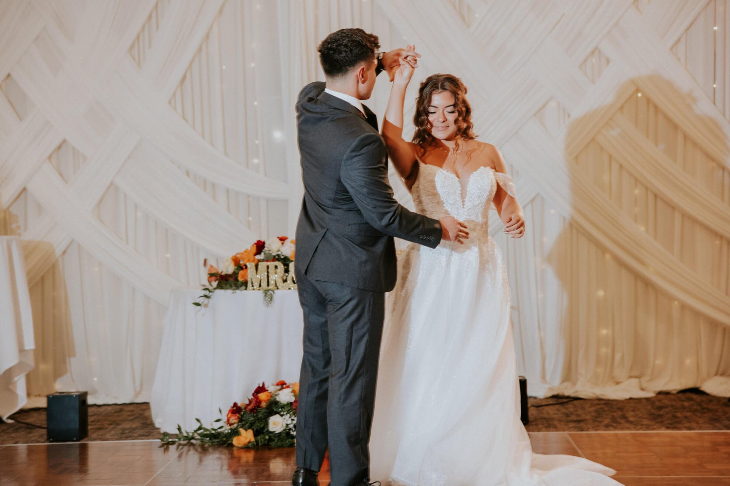 Natalie and David's first dance in front of draped fabric