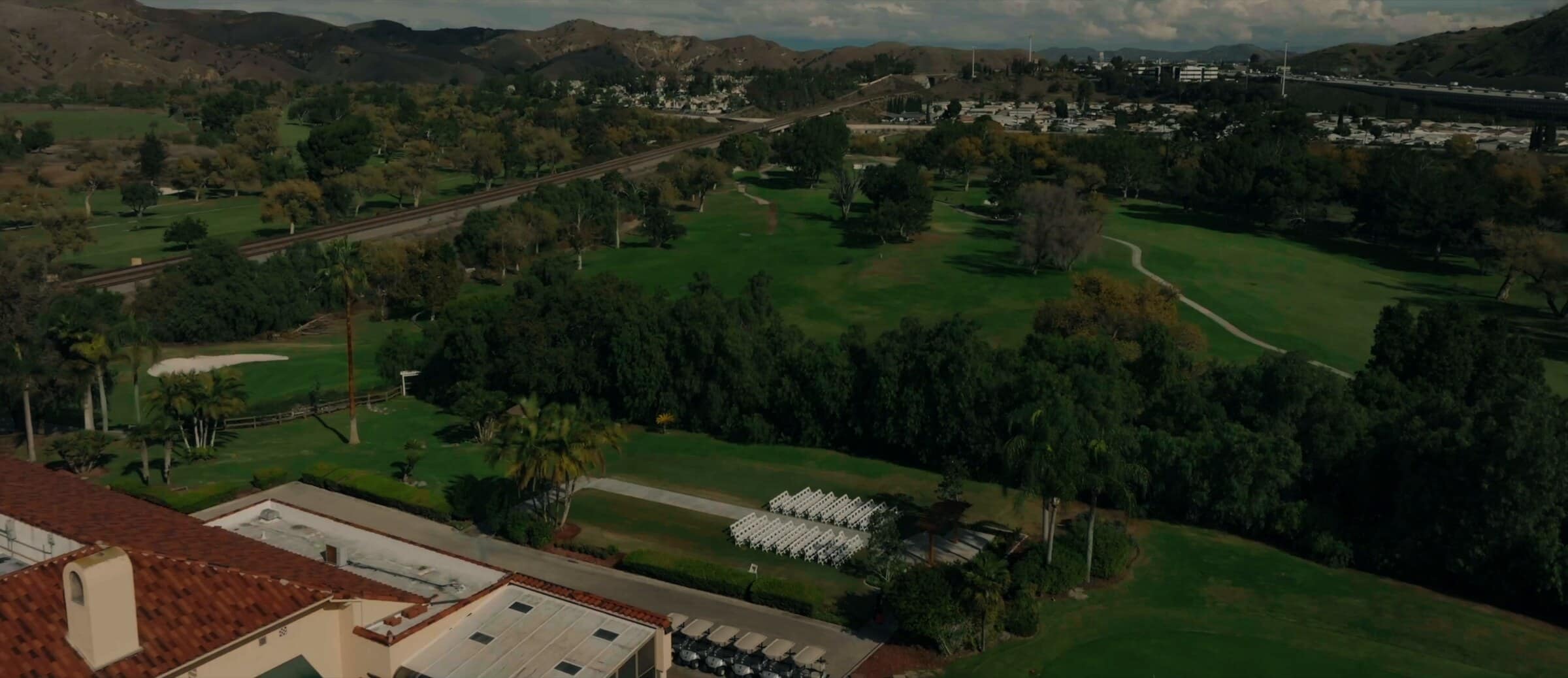 Aerial view over the venue's lawns and golf course toward the hills