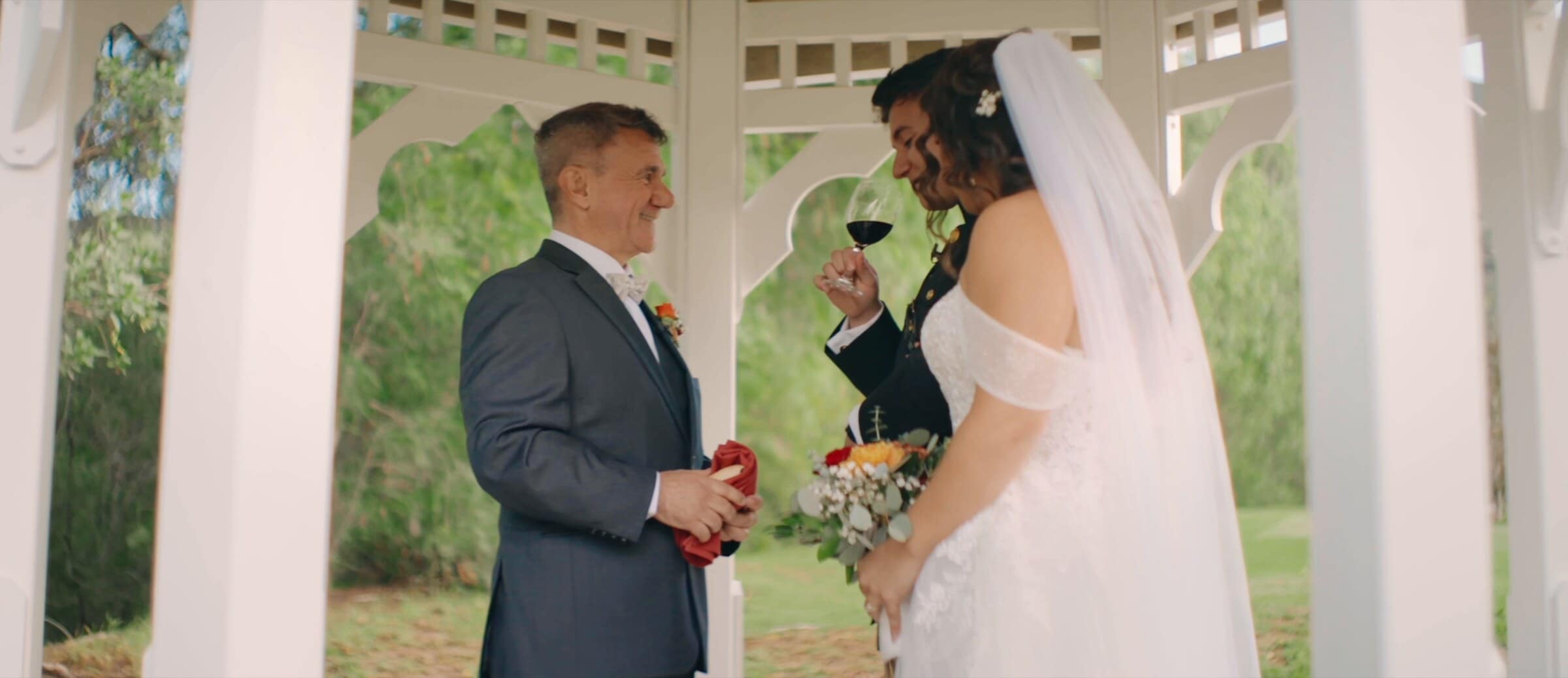Natalie sipping red wine in a white gazebo before the ceremony