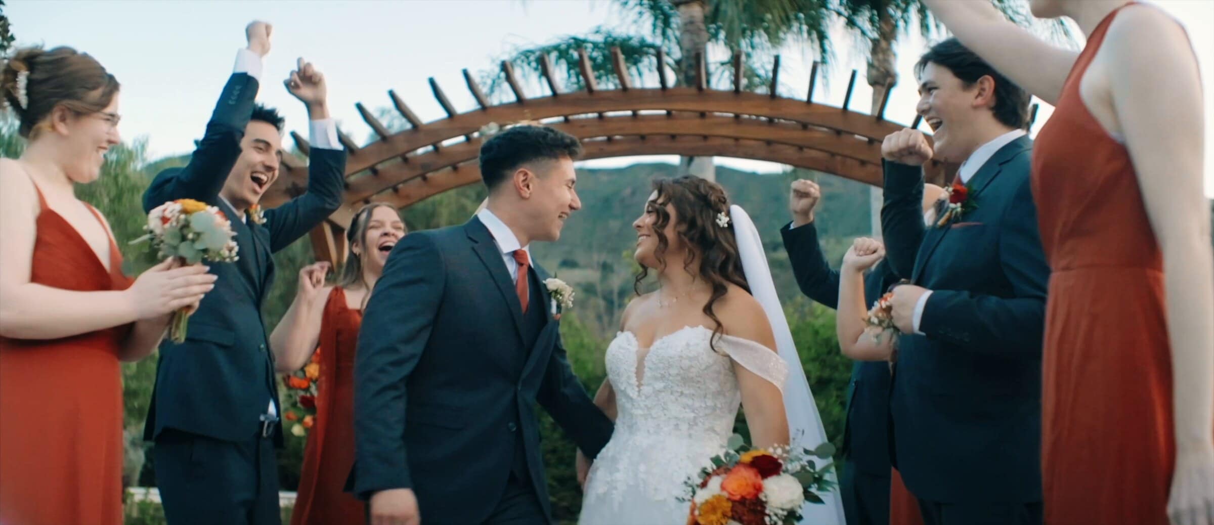 Natalie and David walking back up the aisle as the wedding party cheers