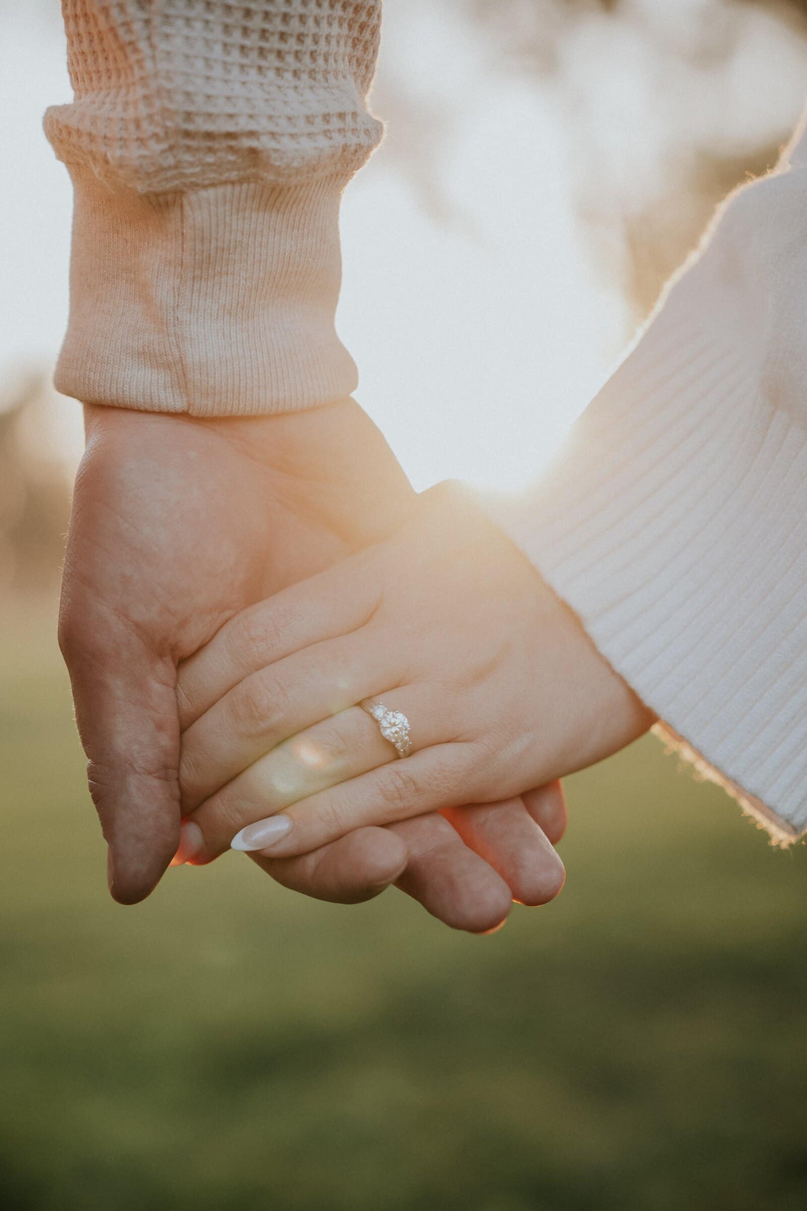 Their hands clasped, the ring on one finger