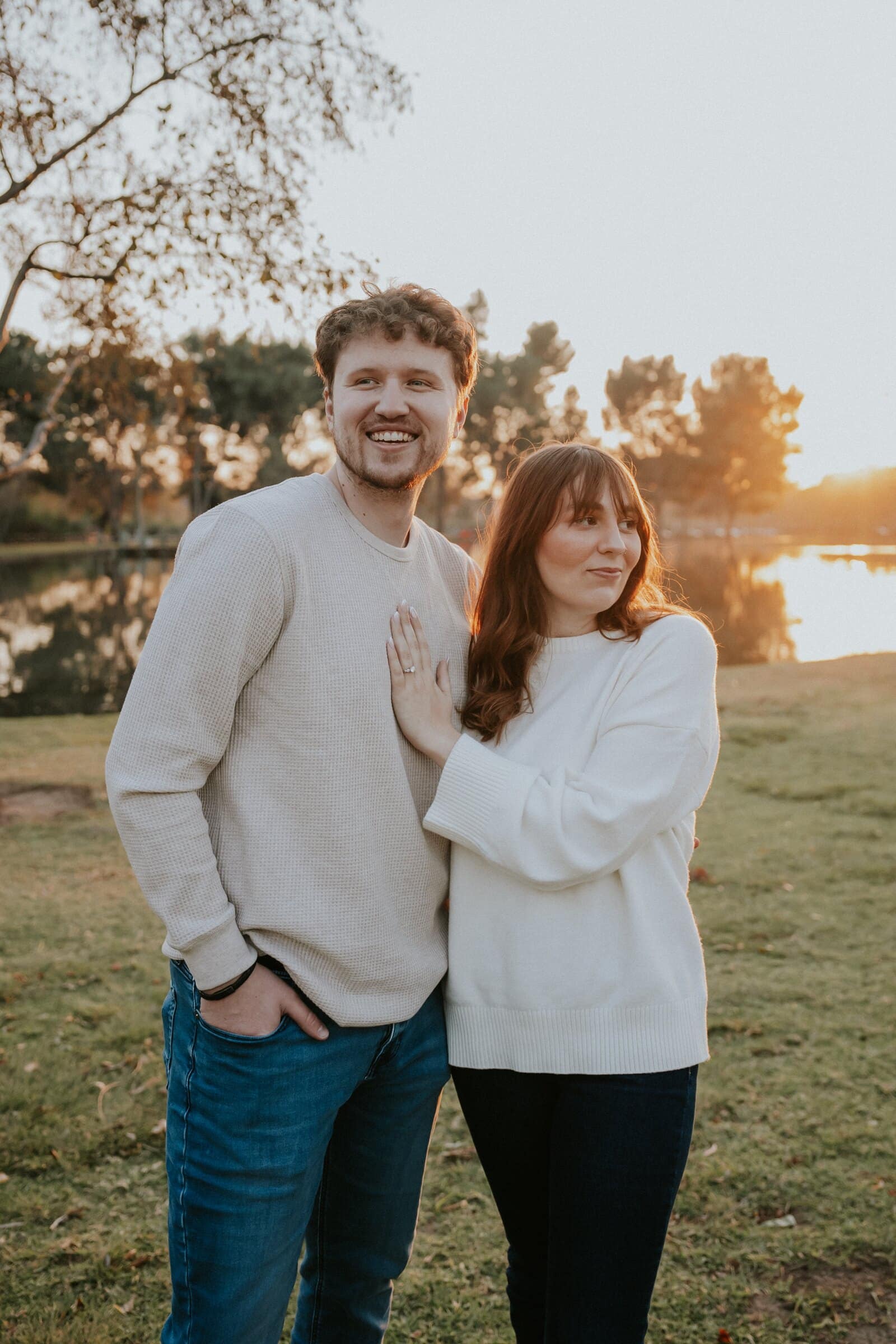 Nick and Ren standing side by side by a lake, smiling
