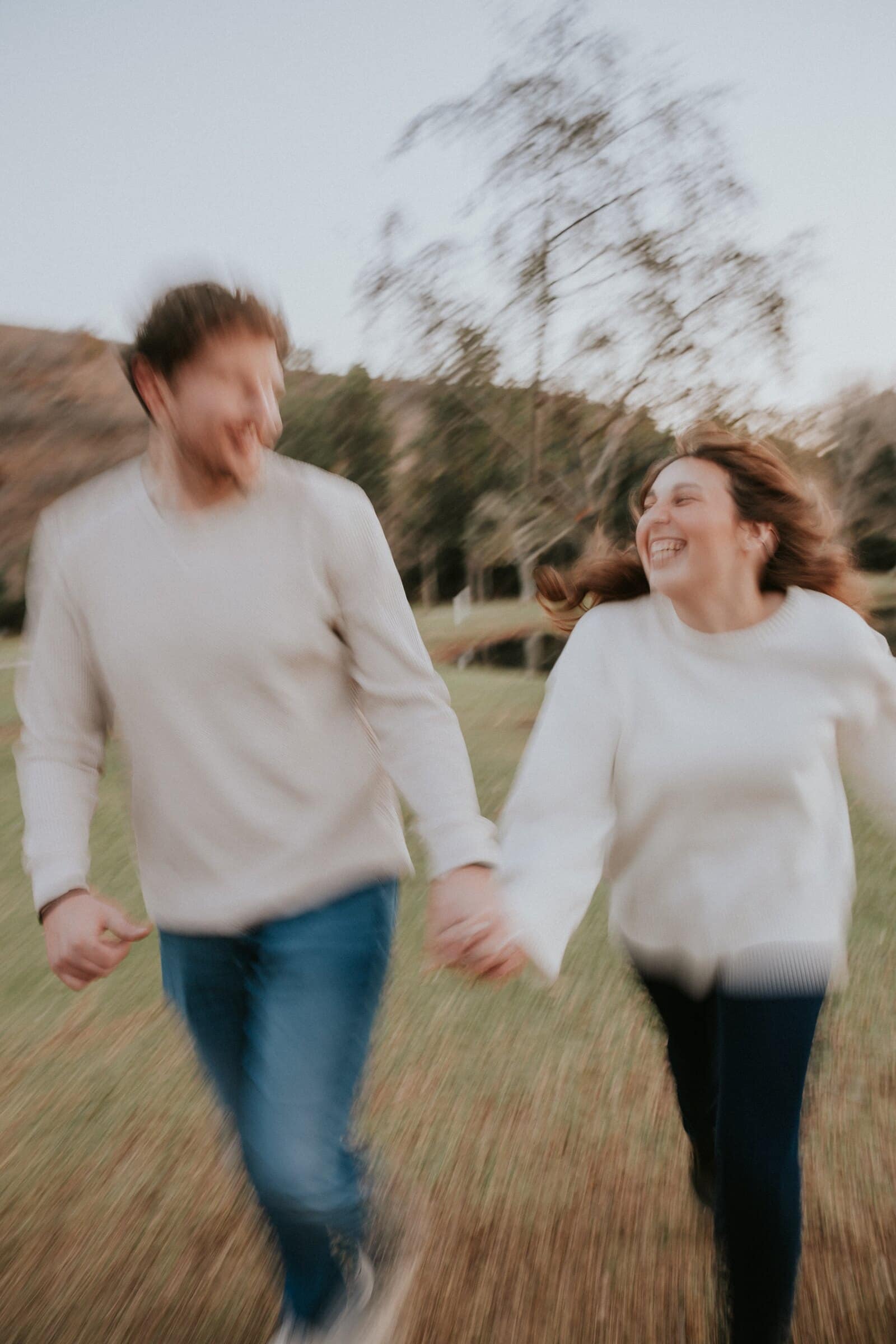 Nick and Ren running hand in hand across the grass