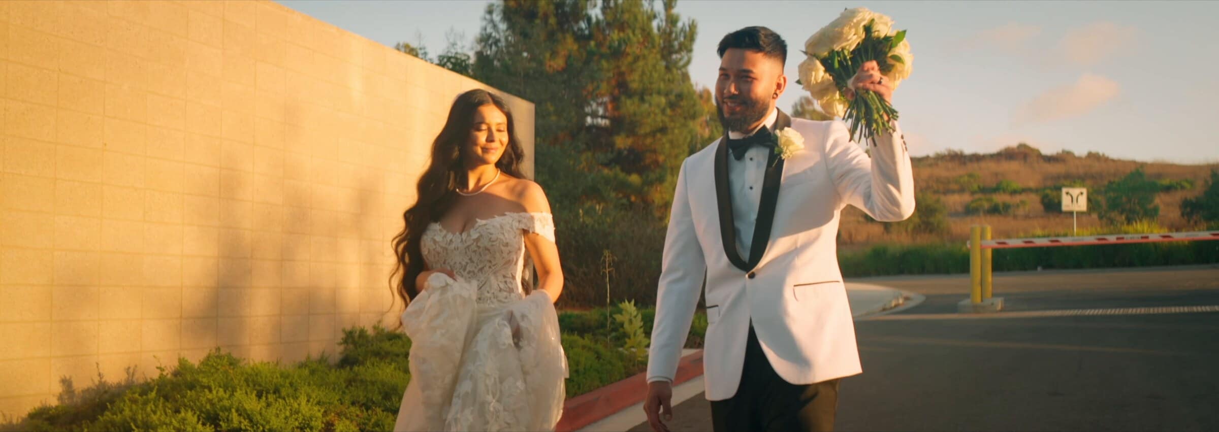 Rubi and Francis laughing at sunset, a bouquet raised in the air