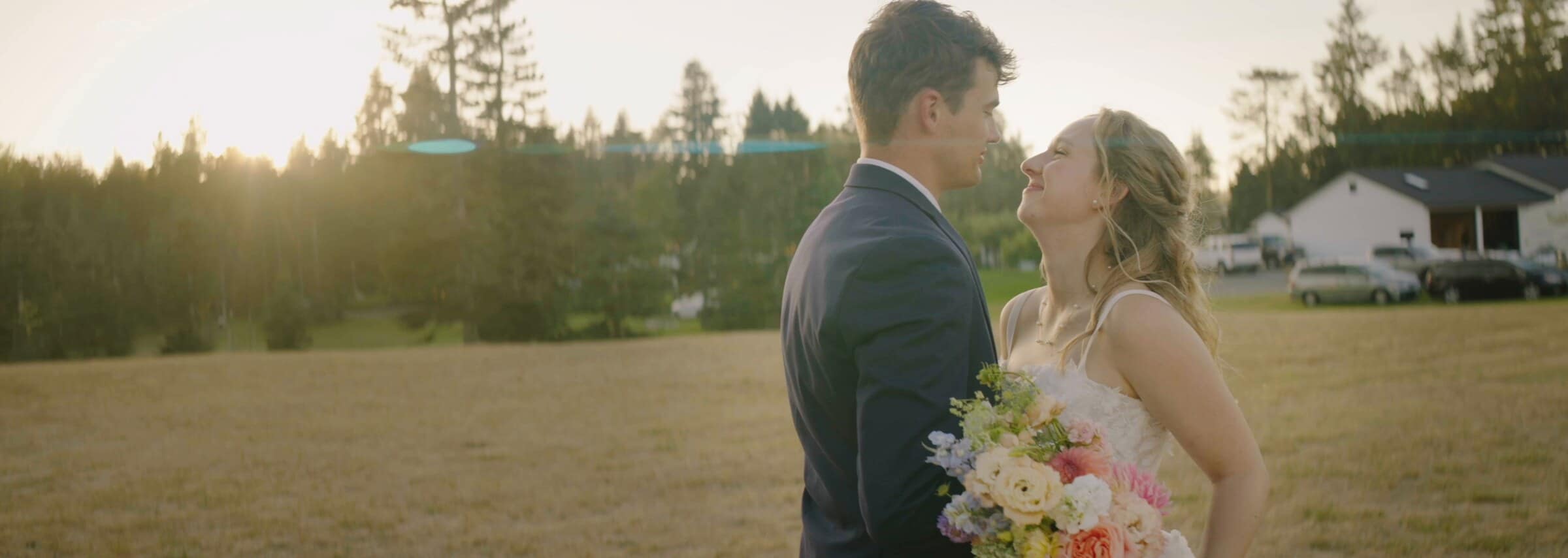 Sarah and Trent face to face in a golden field, her bouquet in hand